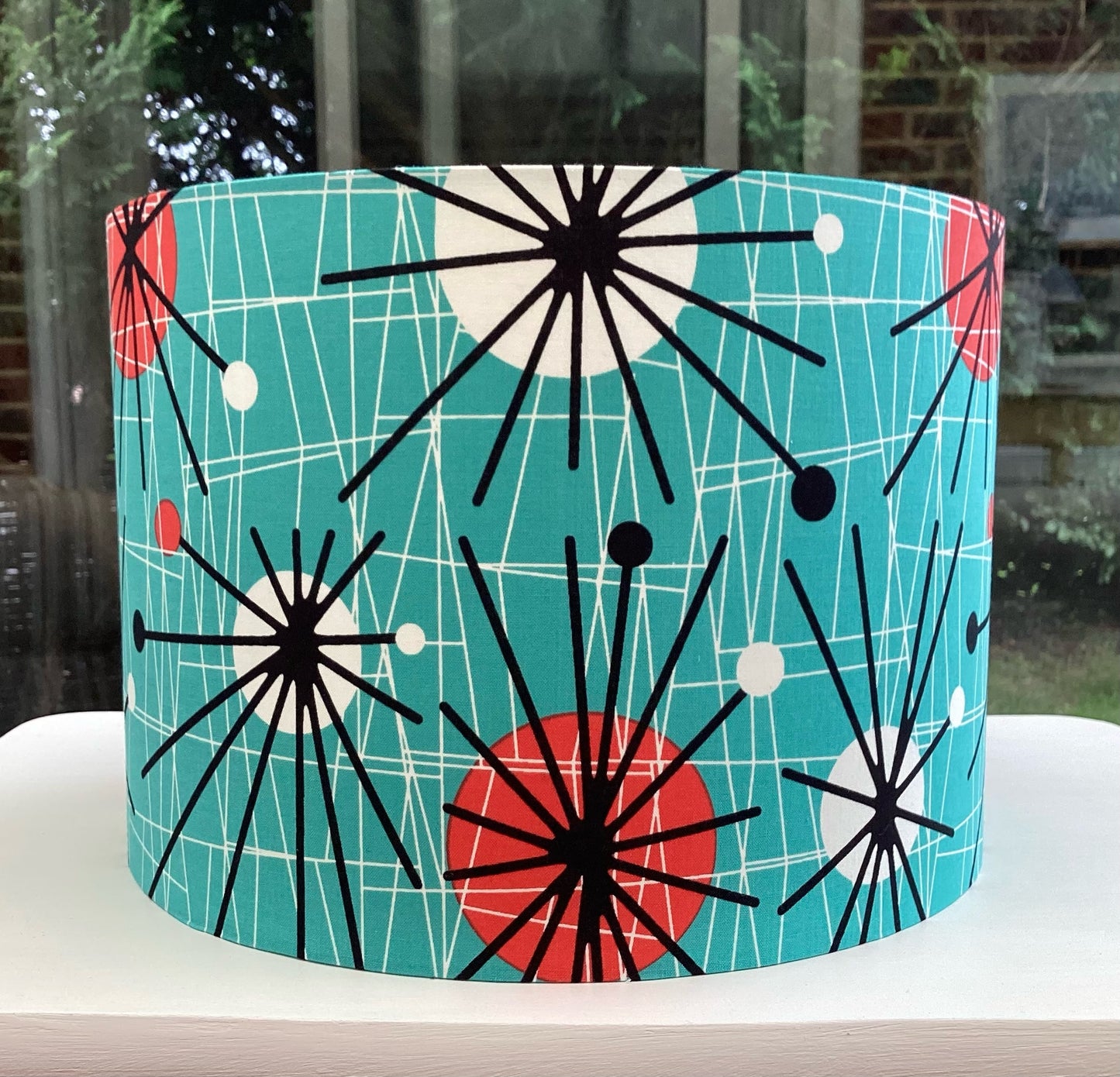 Atomic Kitten teal lampshade with retro-inspired geometric design, perfect for adding a bold, stylish accent to modern home interiors.