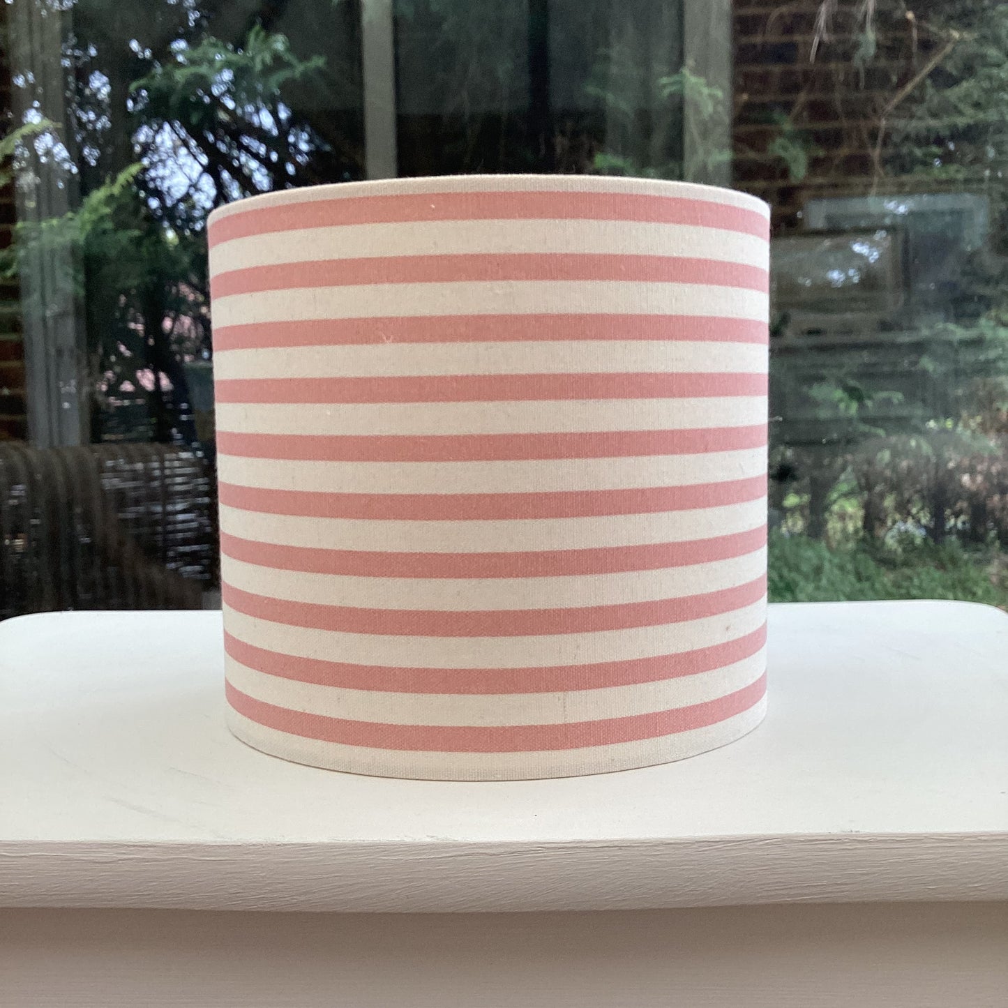Stylish pink striped lampshade with soft hues of blush and white, offering a modern and chic design to complement any room decor.