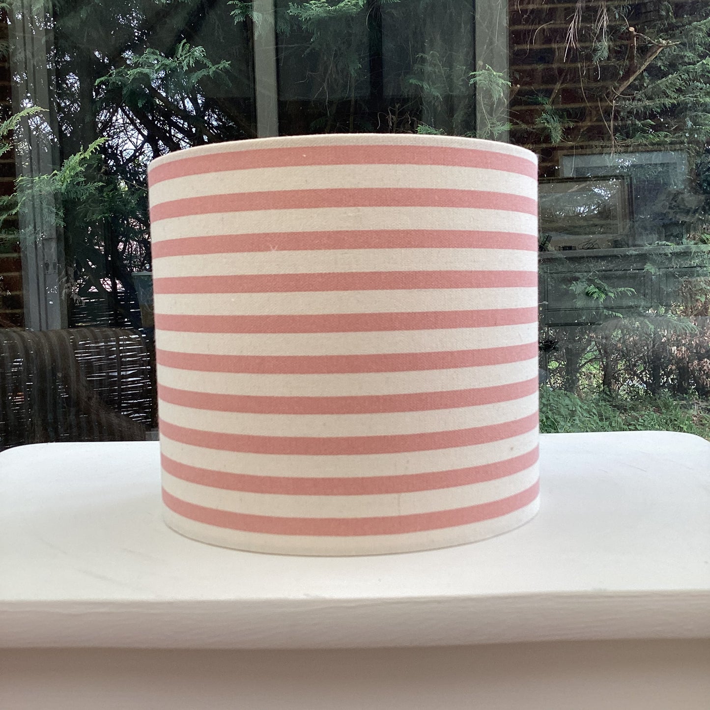 Stylish pink striped lampshade with soft hues of blush and white, offering a modern and chic design to complement any room decor.