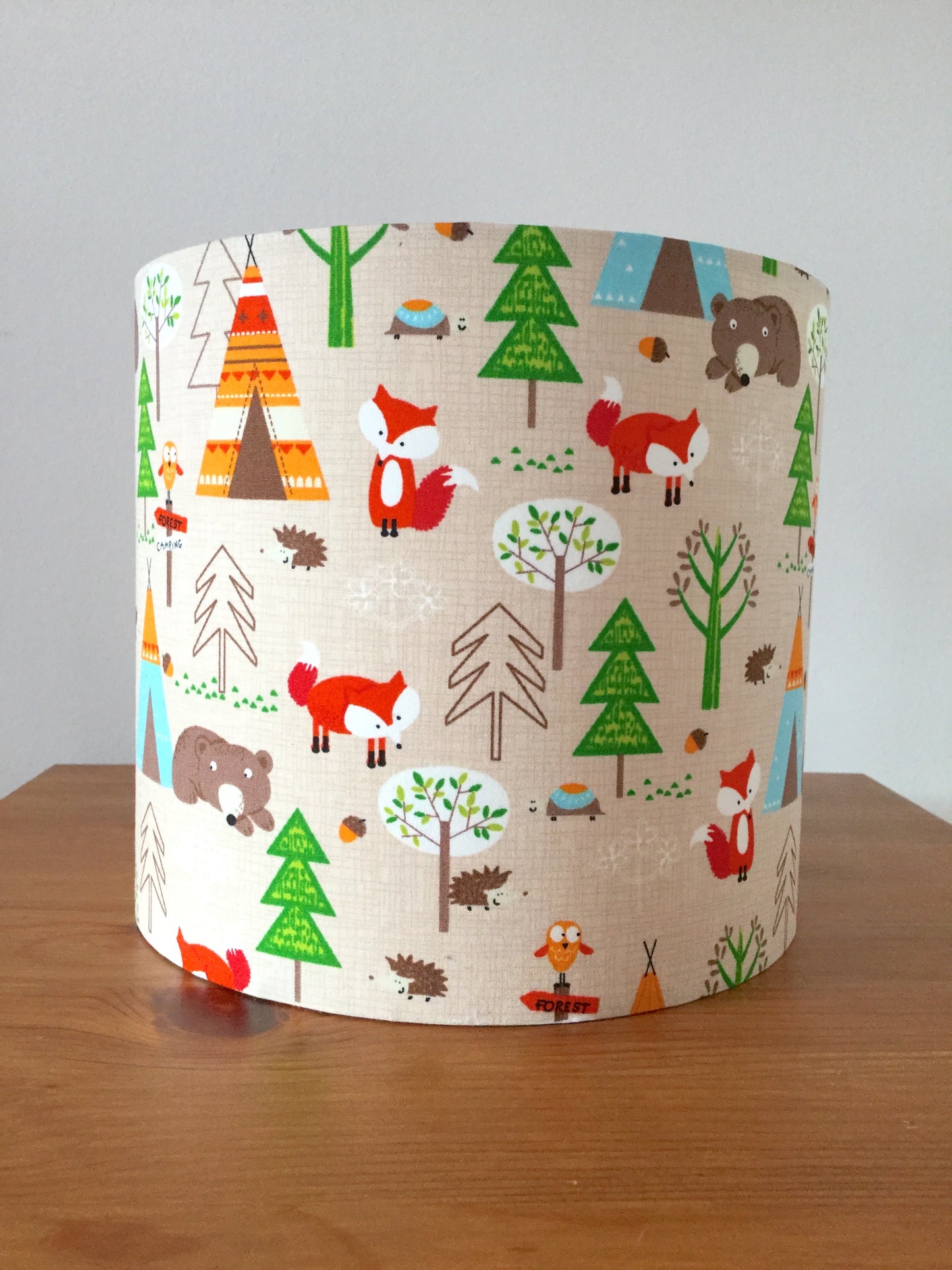Whimsical nursery lampshade with a camping and wildlife theme, featuring playful illustrations of animals, tents, and nature elements in soft pastel colors, perfect for a child's room.