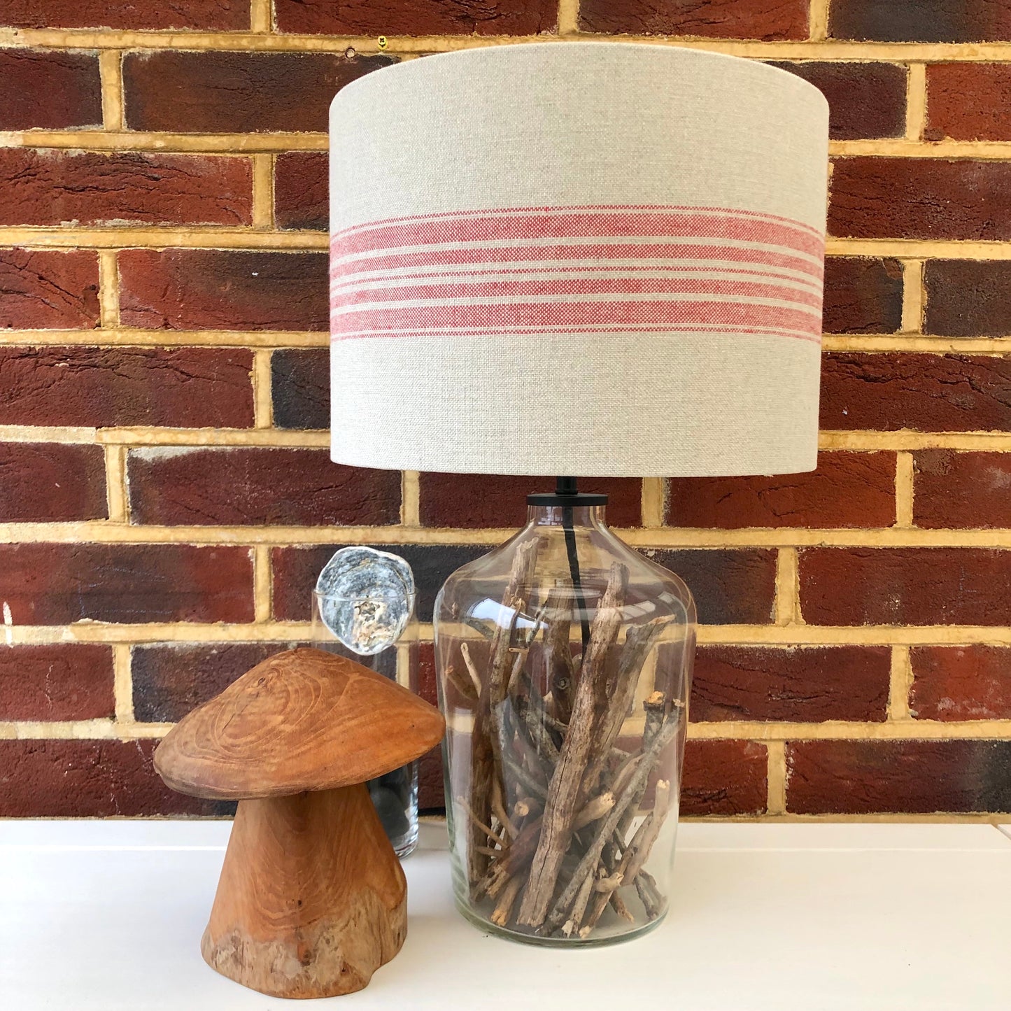 A stylish linen lampshade with bold red stripes, adding a pop of color and texture to any room’s decor.