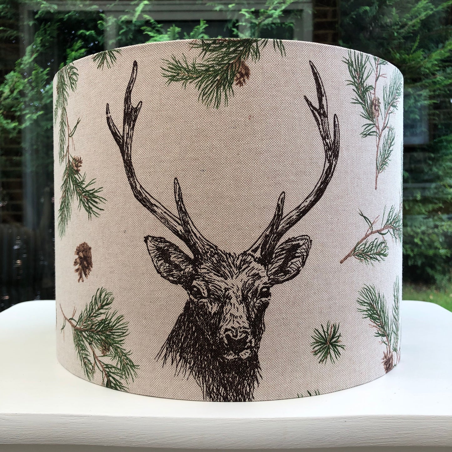 Rustic stag head lampshade with a detailed pine forest design, perfect for woodland-themed decor and cozy interior lighting.