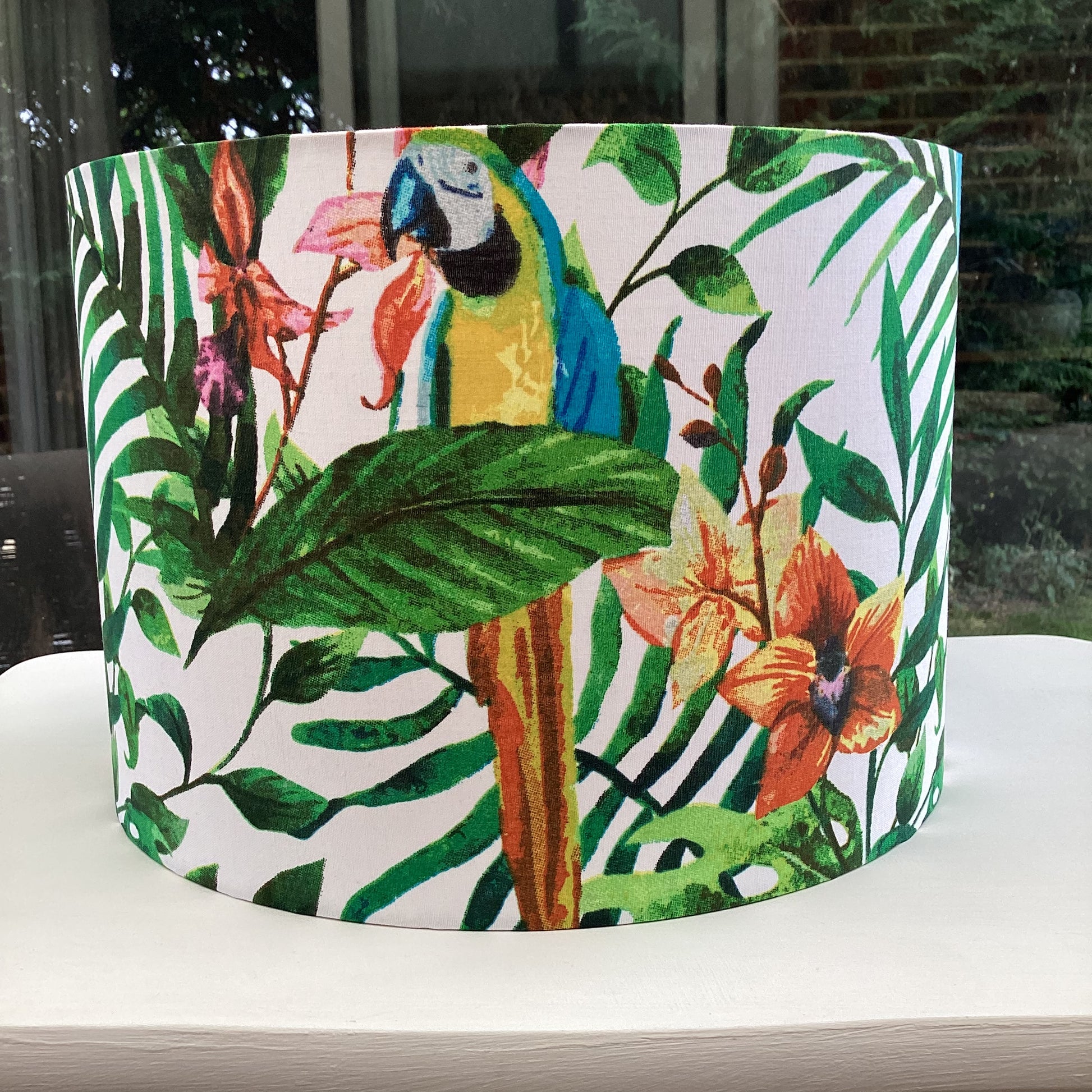 Tropical lampshade with vibrant parrots and green foliage, ideal for adding exotic flair to home decor – handcrafted and unique lighting accessory.