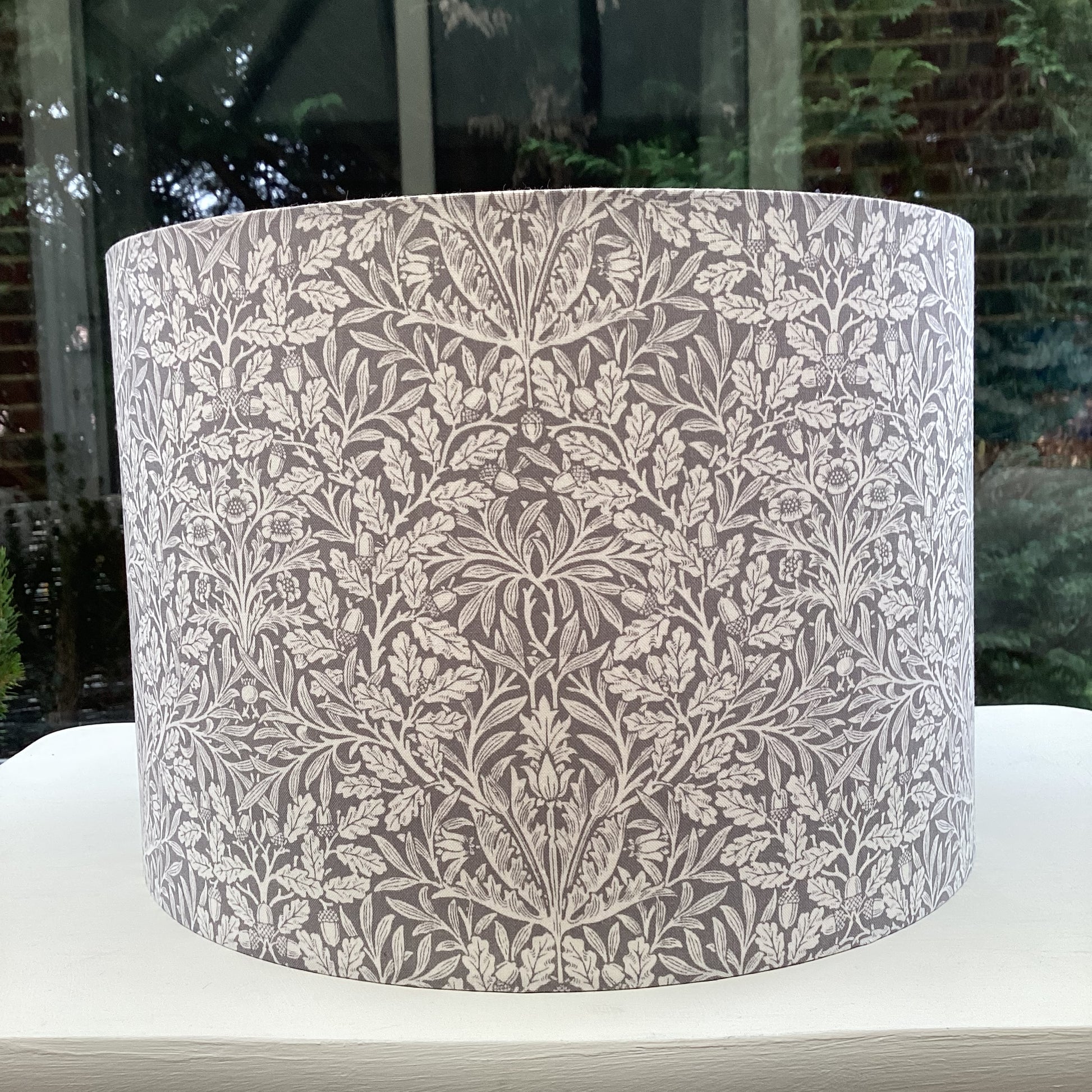 Gray lampshade featuring an artistic acorn pattern, adding a touch of nature-inspired charm to any space.