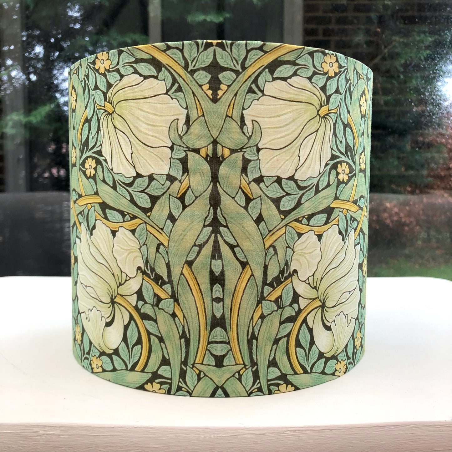 Green lampshade featuring a floral pattern, adding a touch of nature-inspired charm to any space.