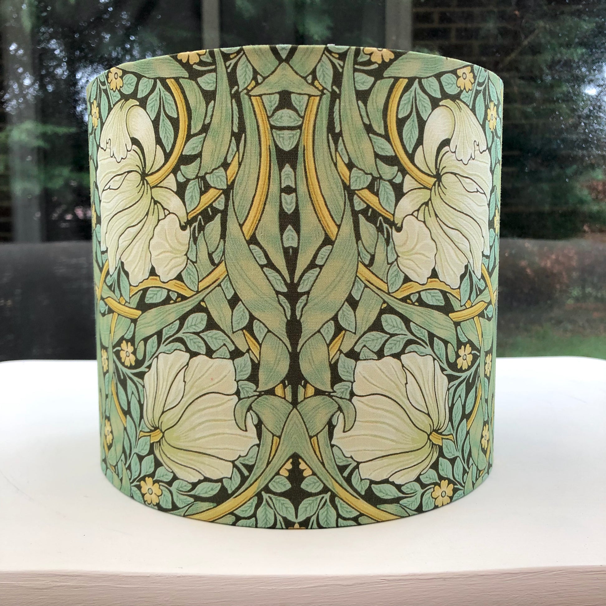 Green lampshade featuring a floral pattern, adding a touch of nature-inspired charm to any space.