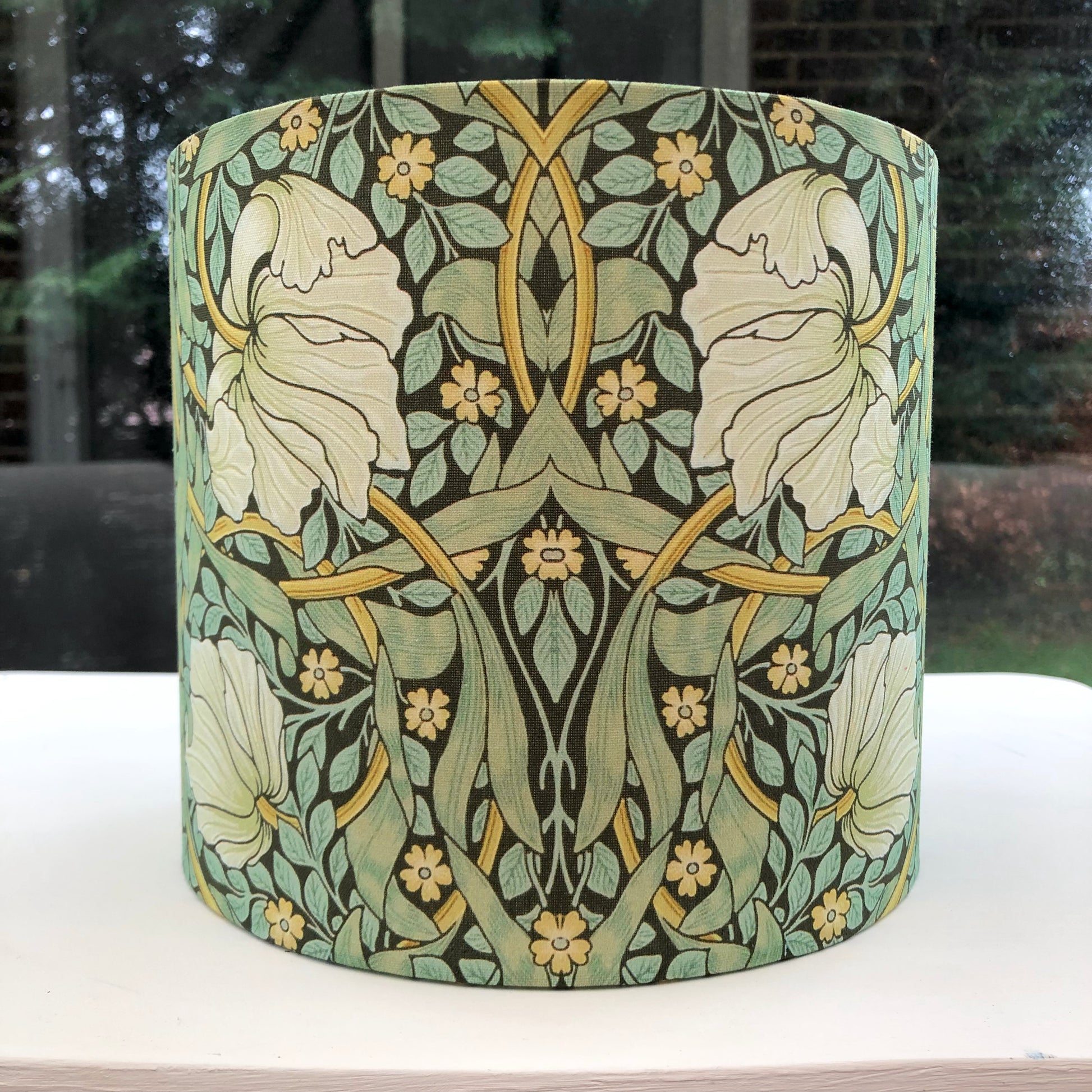 Green lampshade featuring a floral pattern, adding a touch of nature-inspired charm to any space.