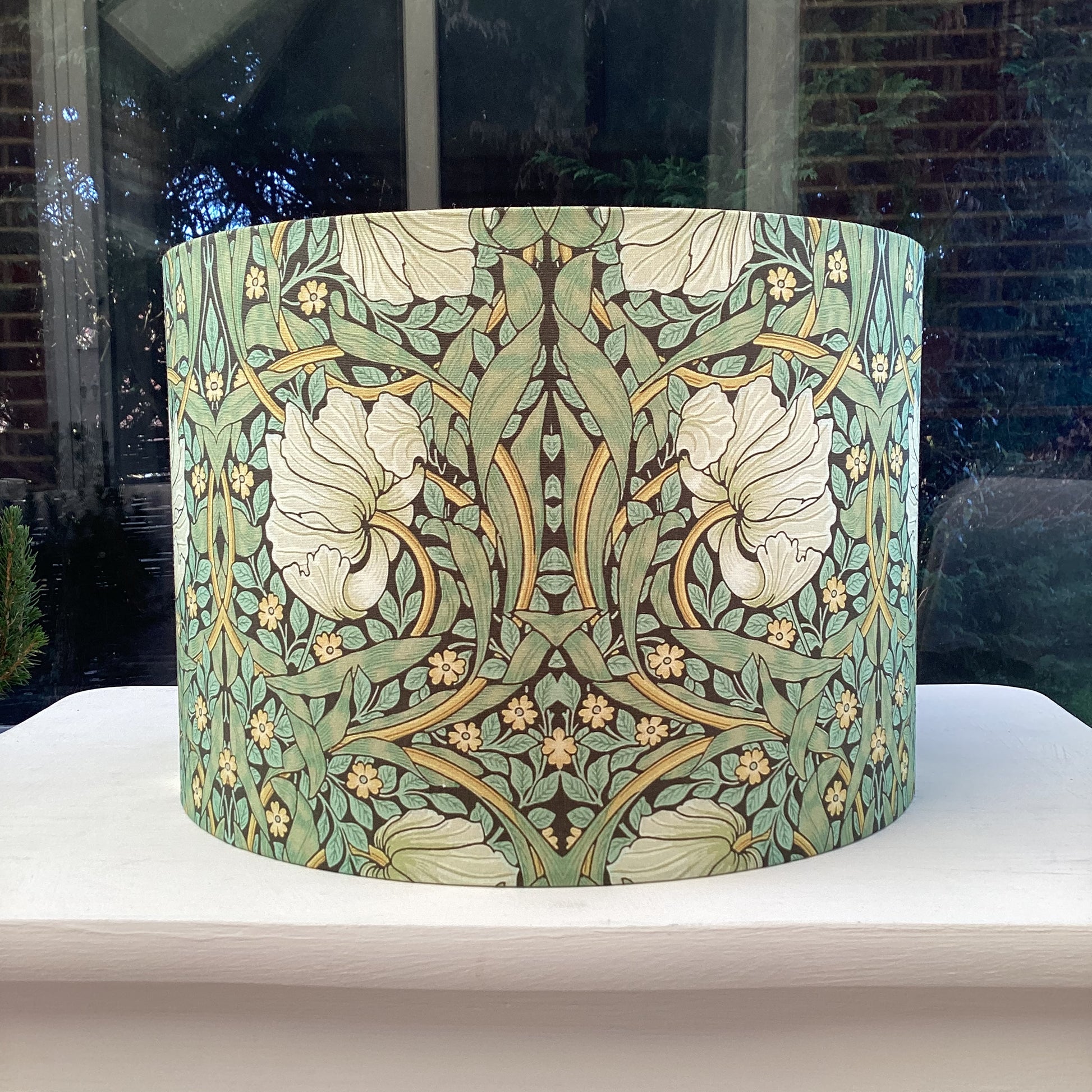 Green lampshade featuring a floral pattern, adding a touch of nature-inspired charm to any space.