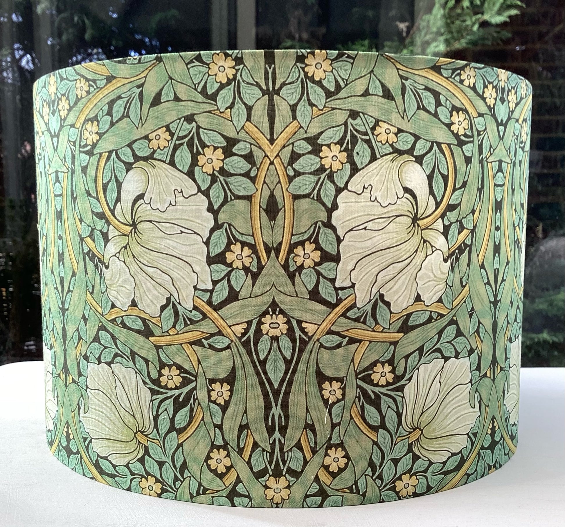 Green lampshade featuring a floral pattern, adding a touch of nature-inspired charm to any space.