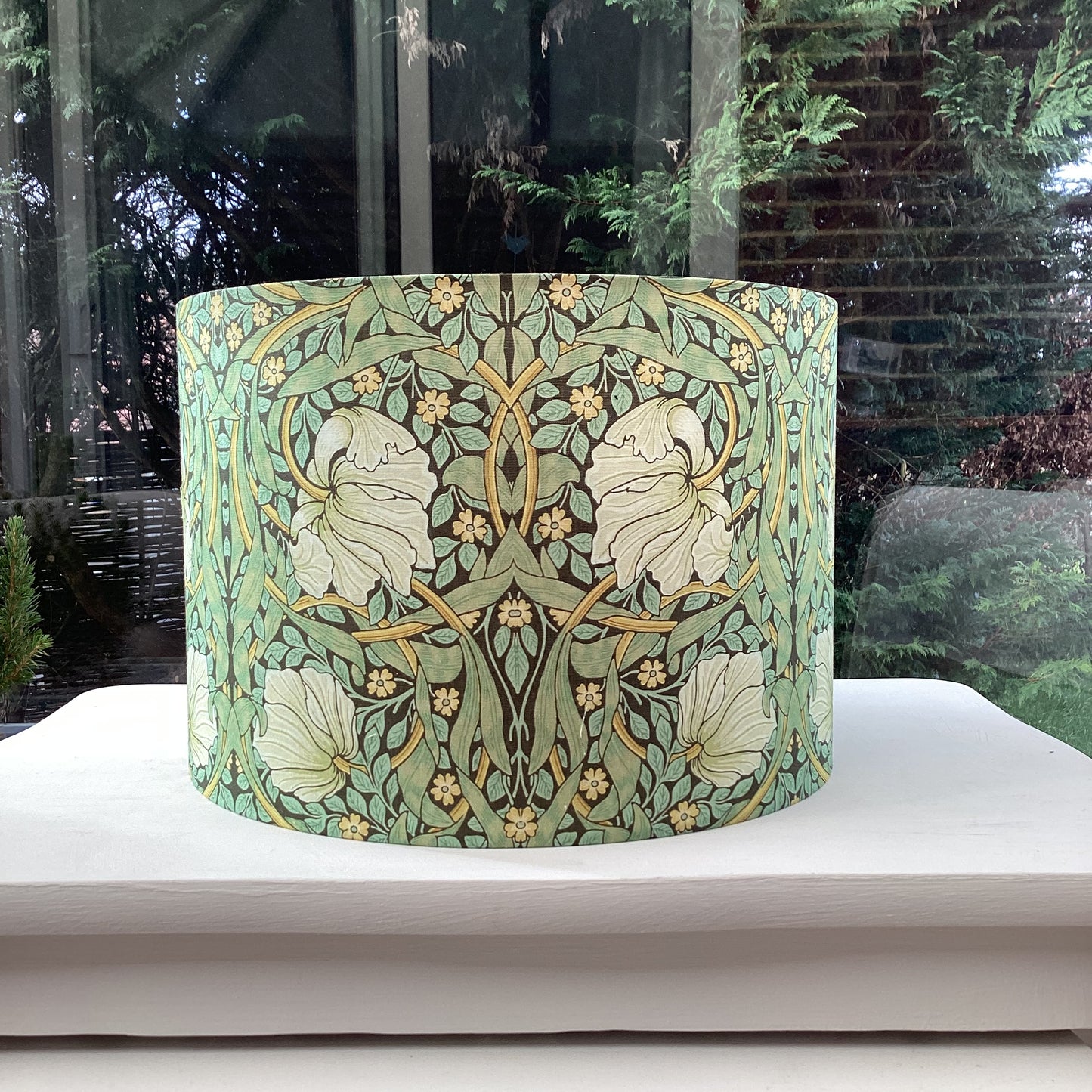 Green lampshade featuring a floral pattern, adding a touch of nature-inspired charm to any space.