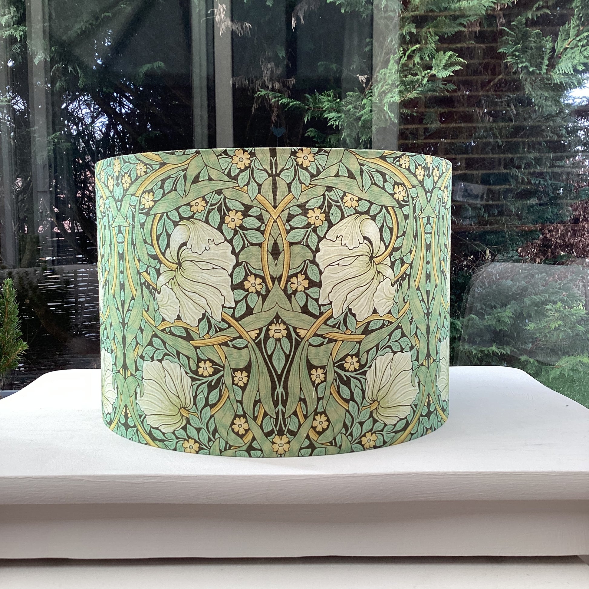 Green lampshade featuring a floral pattern, adding a touch of nature-inspired charm to any space.