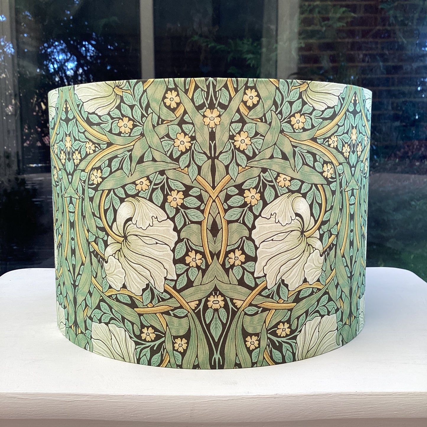 Green lampshade featuring a floral pattern, adding a touch of nature-inspired charm to any space.