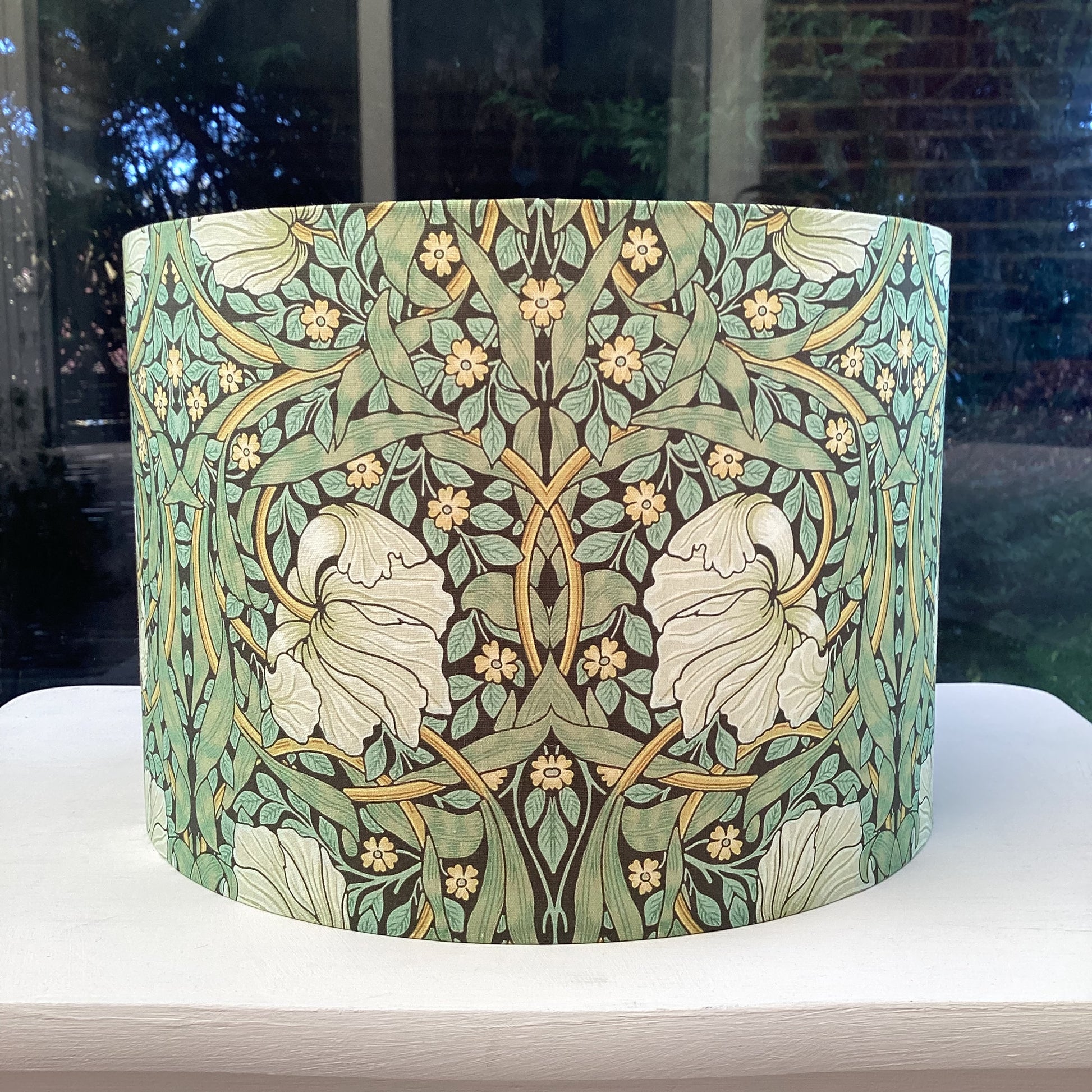 Green lampshade featuring a floral pattern, adding a touch of nature-inspired charm to any space.