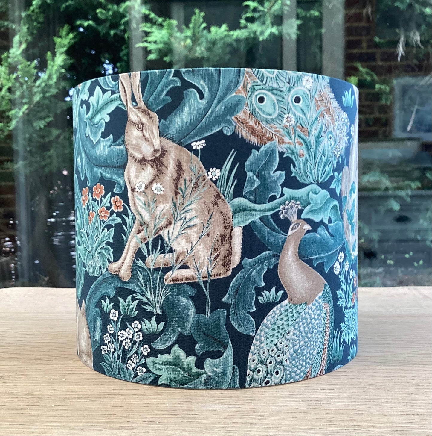 Handcrafted William Morris lampshade in the Standen Forest design, showcasing intricate green and cream botanical patterns, perfect for adding timeless elegance to home lighting decor.