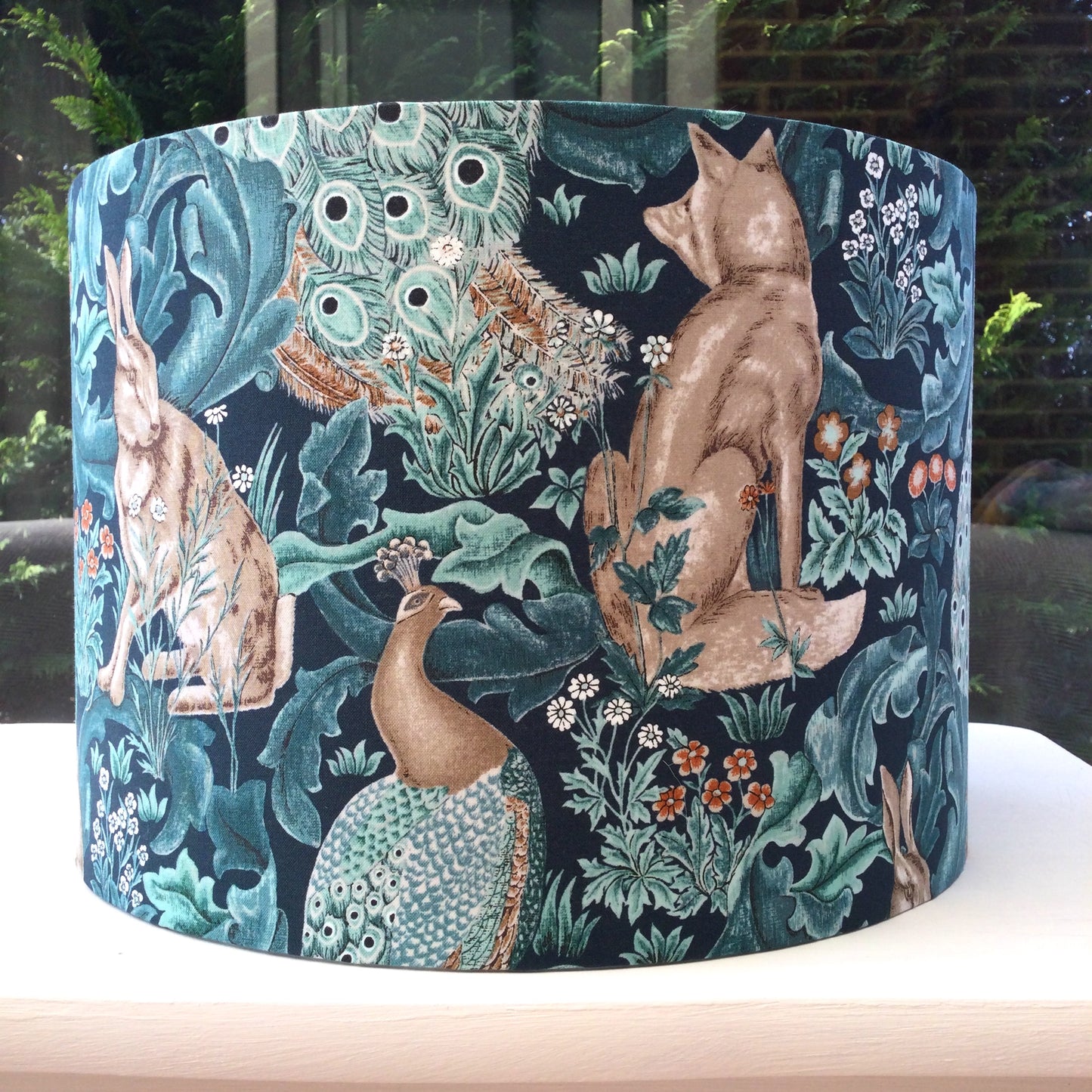 Handcrafted William Morris lampshade in the Standen Forest design, showcasing intricate green and cream botanical patterns, perfect for adding timeless elegance to home lighting decor.