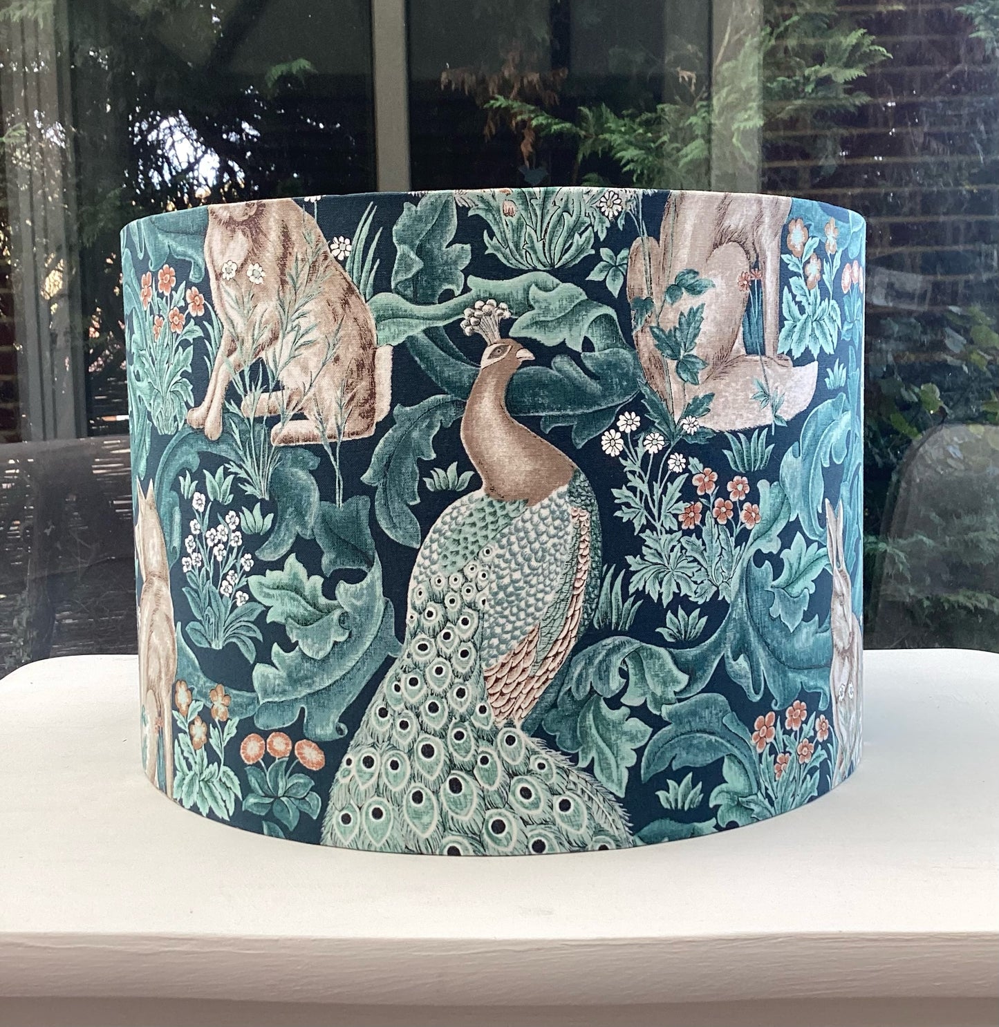 Handcrafted William Morris lampshade in the Standen Forest design, showcasing intricate green and cream botanical patterns, perfect for adding timeless elegance to home lighting decor.