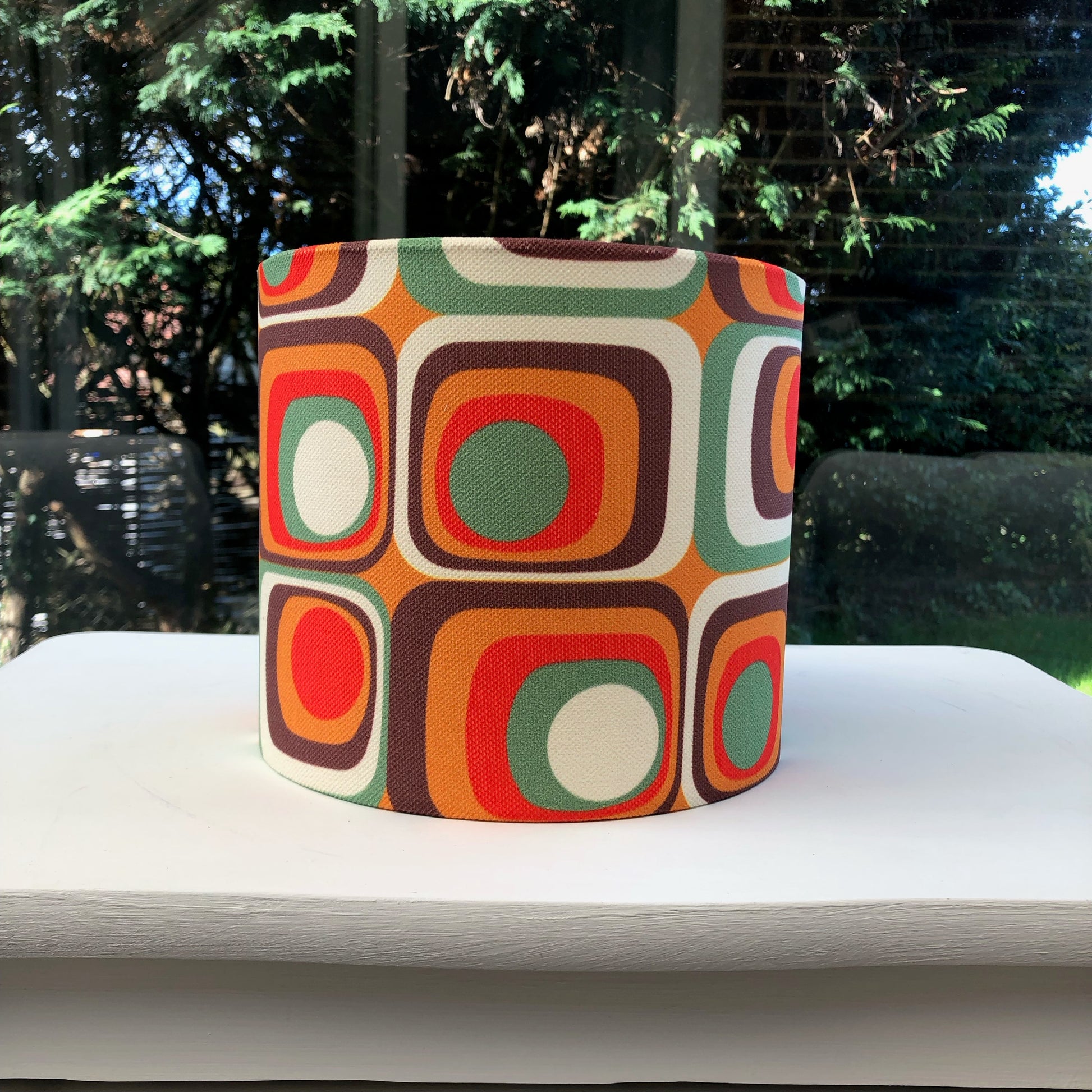 Colorful retro-inspired lampshade with bold geometric patterns, reminiscent of 1960s design aesthetics.