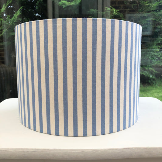 Blue striped lampshade with a modern design, perfect for adding a stylish touch to contemporary home decor. Handcrafted with high-quality materials, this unique lampshade enhances any room with its vibrant colors and elegant pattern.