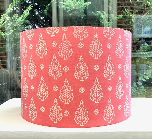 A soft, blush pink lampshade adorned with delicate rose designs, perfect for creating a warm and inviting atmosphere in a spring nursery or cozy bedroom.