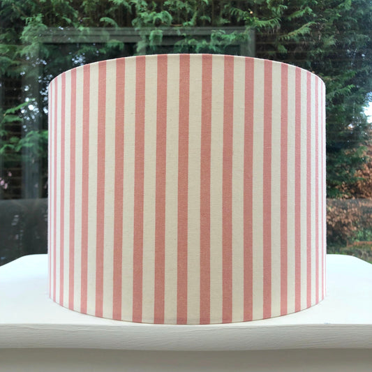 Pink and white striped lampshade with a modern design, casting soft ambient lighting.