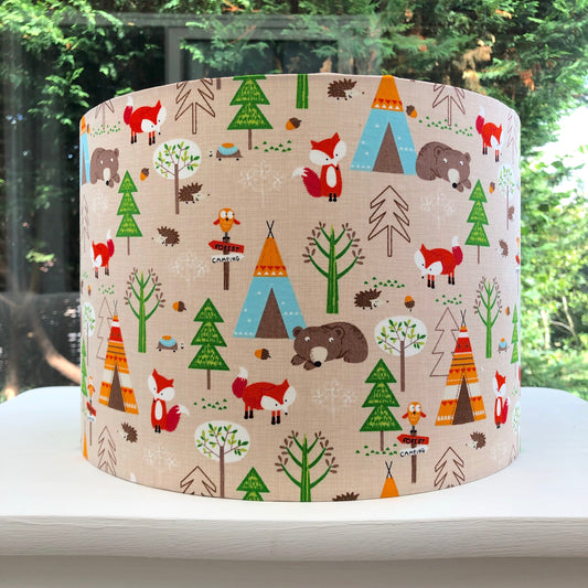 Whimsical nursery lampshade with a camping and wildlife theme, featuring playful illustrations of animals, tents, and nature elements in soft pastel colors, perfect for a child's room.