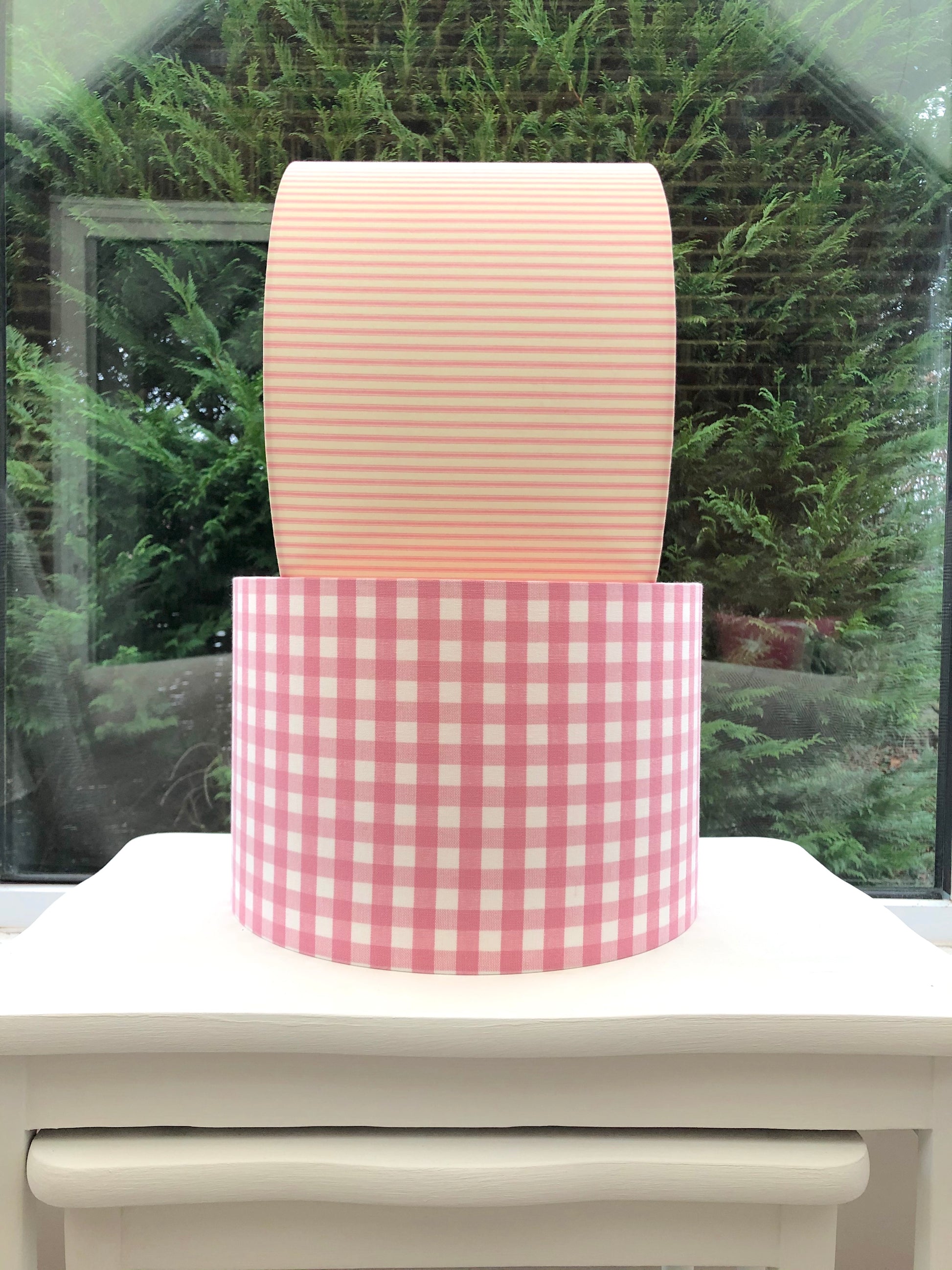 Pink coloured gingham-patterned lampshade, adding a touch of rustic charm to any space.