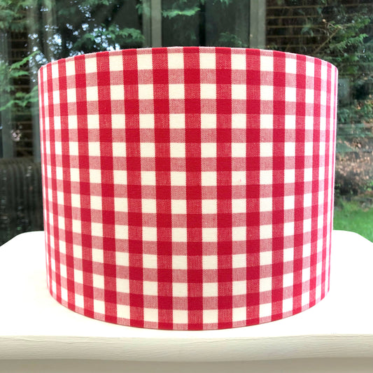 Bright red coloured gingham-patterned lampshade, adding a touch of rustic charm to any space.