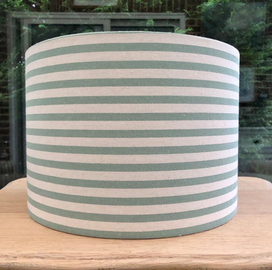 A stylish green striped lampshade with bold, vertical stripes in varying shades of green, offering a modern and vibrant touch to home decor.