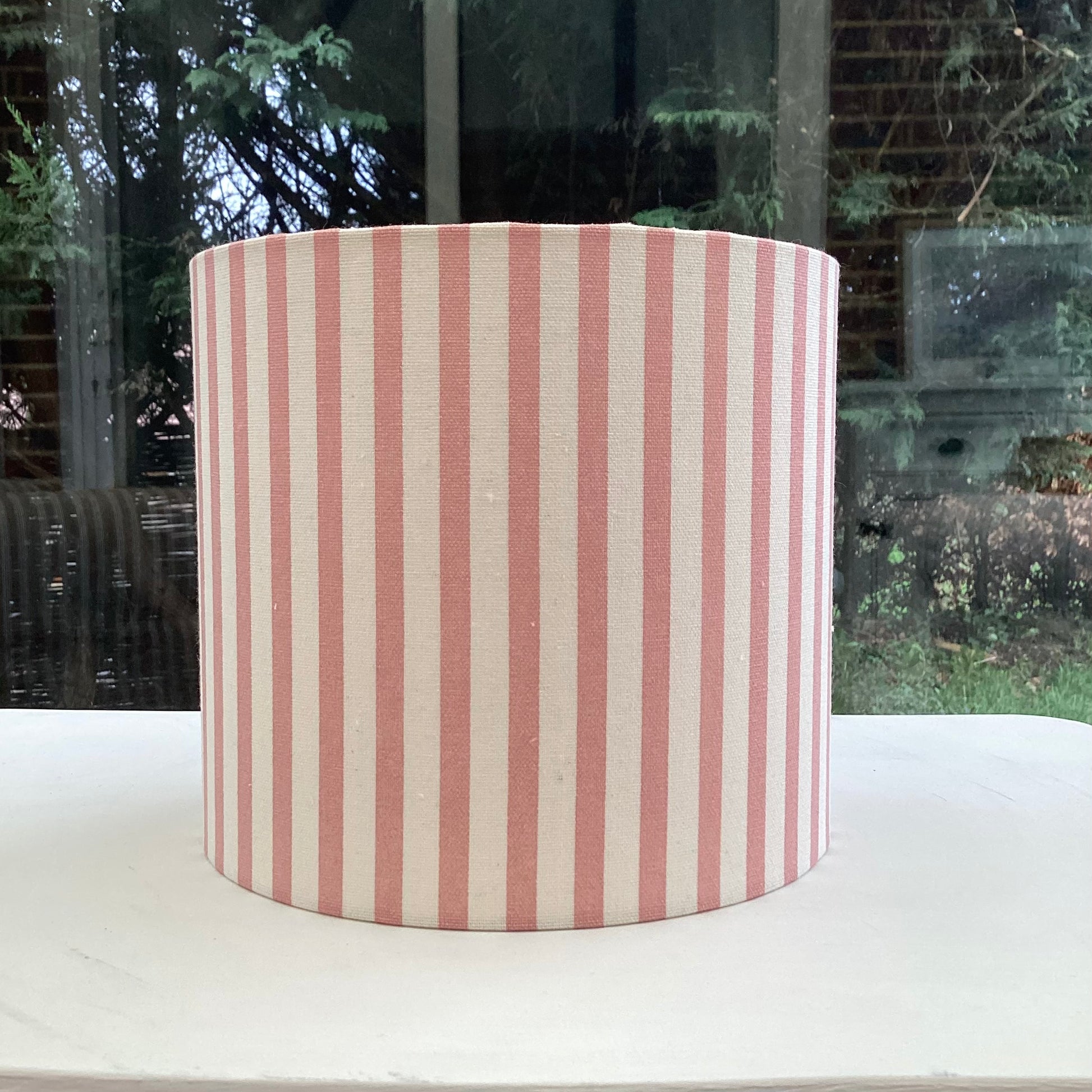 Pink and white striped lampshade with a modern design, casting soft ambient lighting.