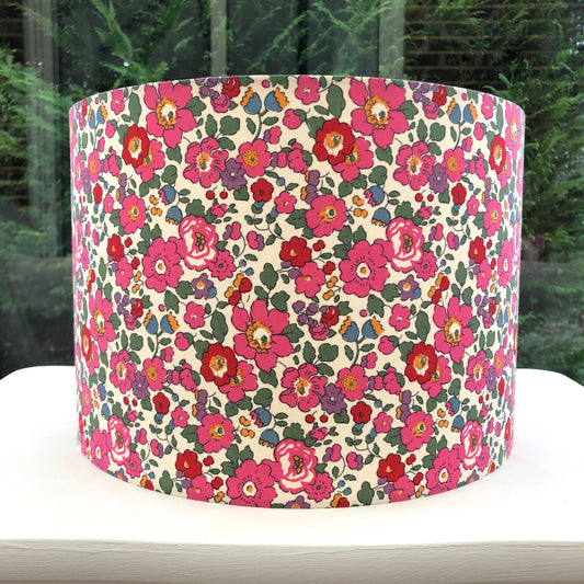 A vibrant floral lampshade in red, pink, and green Liberty Betsy pattern, bringing a lively and stylish touch to any room.