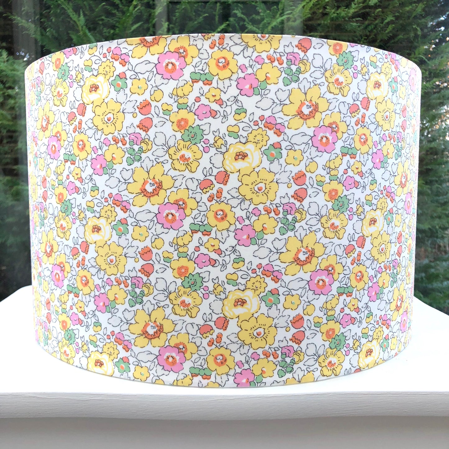 Bright yellow floral lampshade with a Liberty Betsy pattern, showcasing vibrant, detailed flowers in cheerful hues, adding a lively touch to any room.