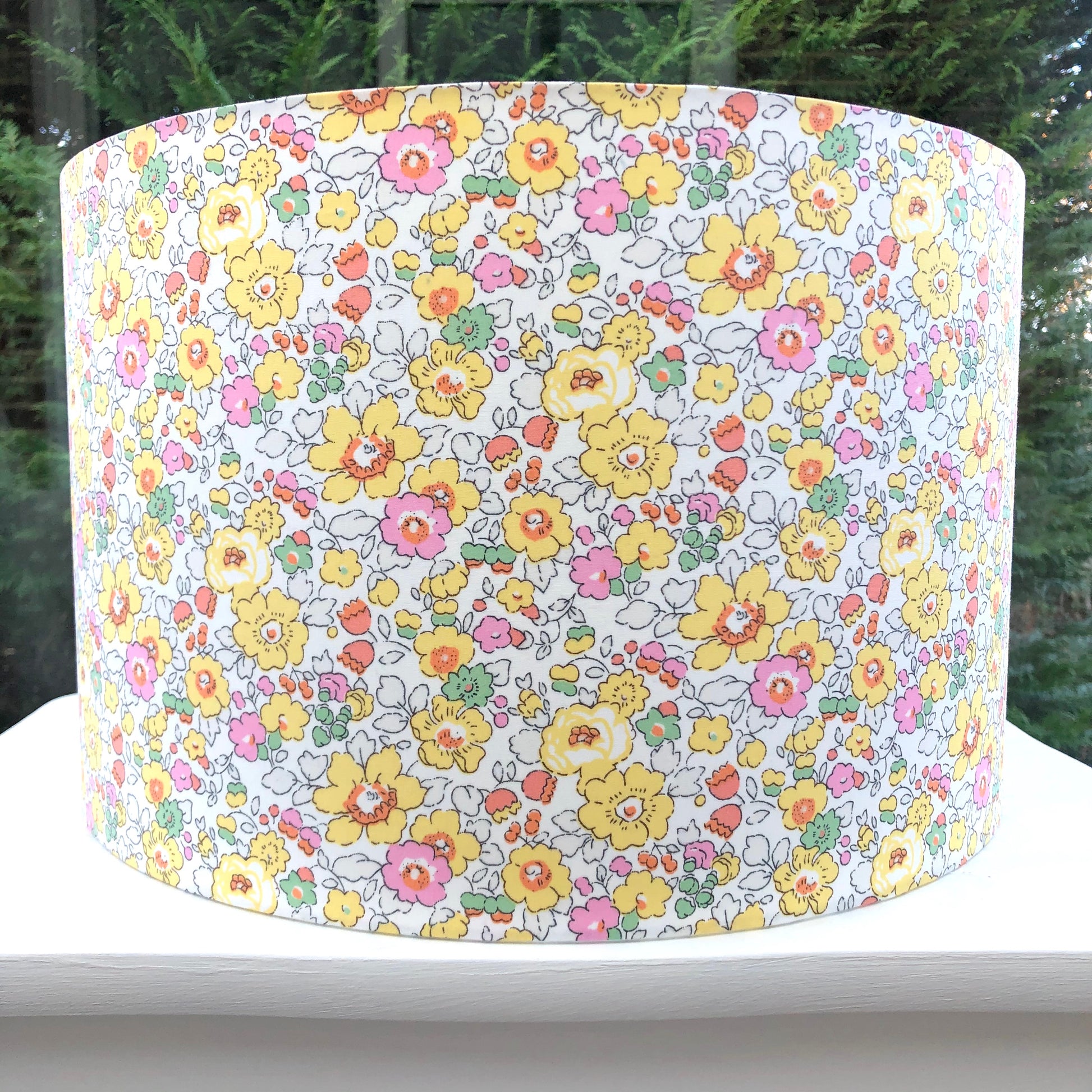 Bright yellow floral lampshade with a Liberty Betsy pattern, showcasing vibrant, detailed flowers in cheerful hues, adding a lively touch to any room.