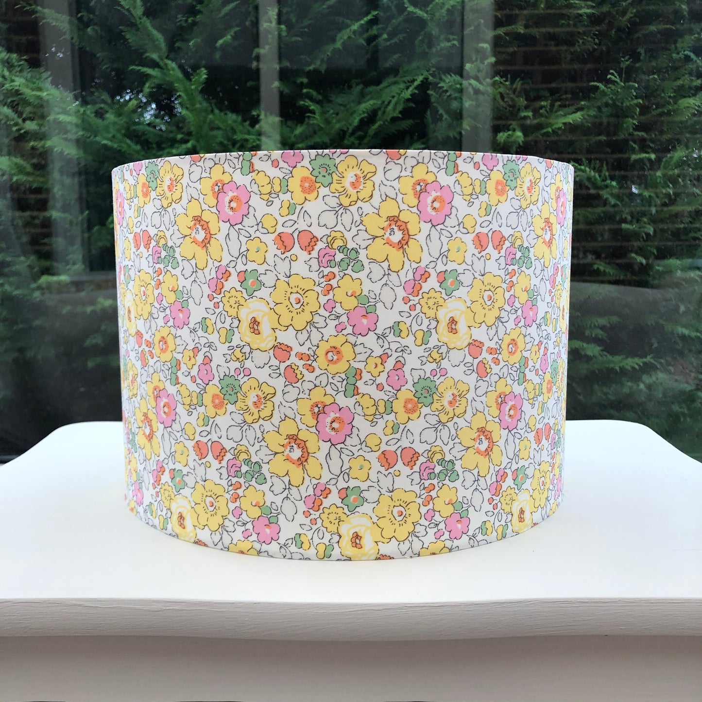 Bright yellow floral lampshade with a Liberty Betsy pattern, showcasing vibrant, detailed flowers in cheerful hues, adding a lively touch to any room.