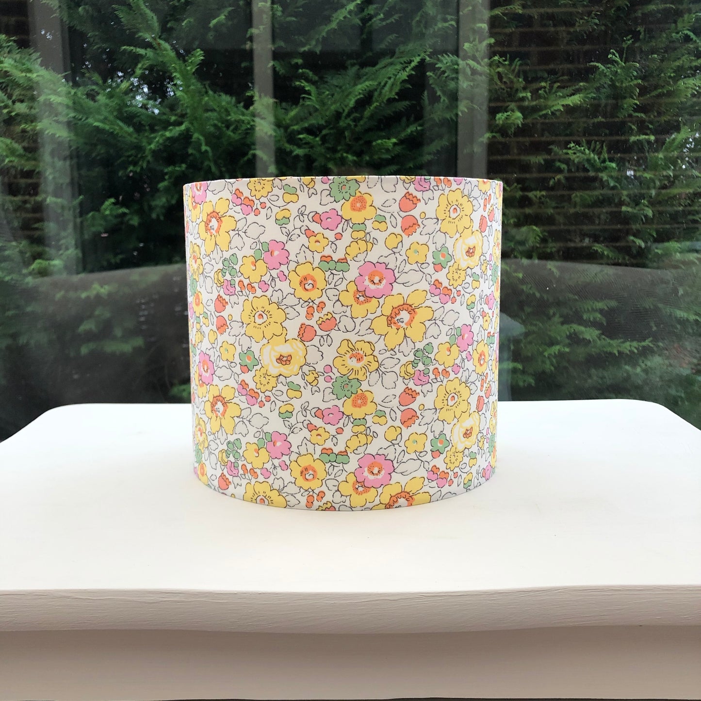 Bright yellow floral lampshade with a Liberty Betsy pattern, showcasing vibrant, detailed flowers in cheerful hues, adding a lively touch to any room.