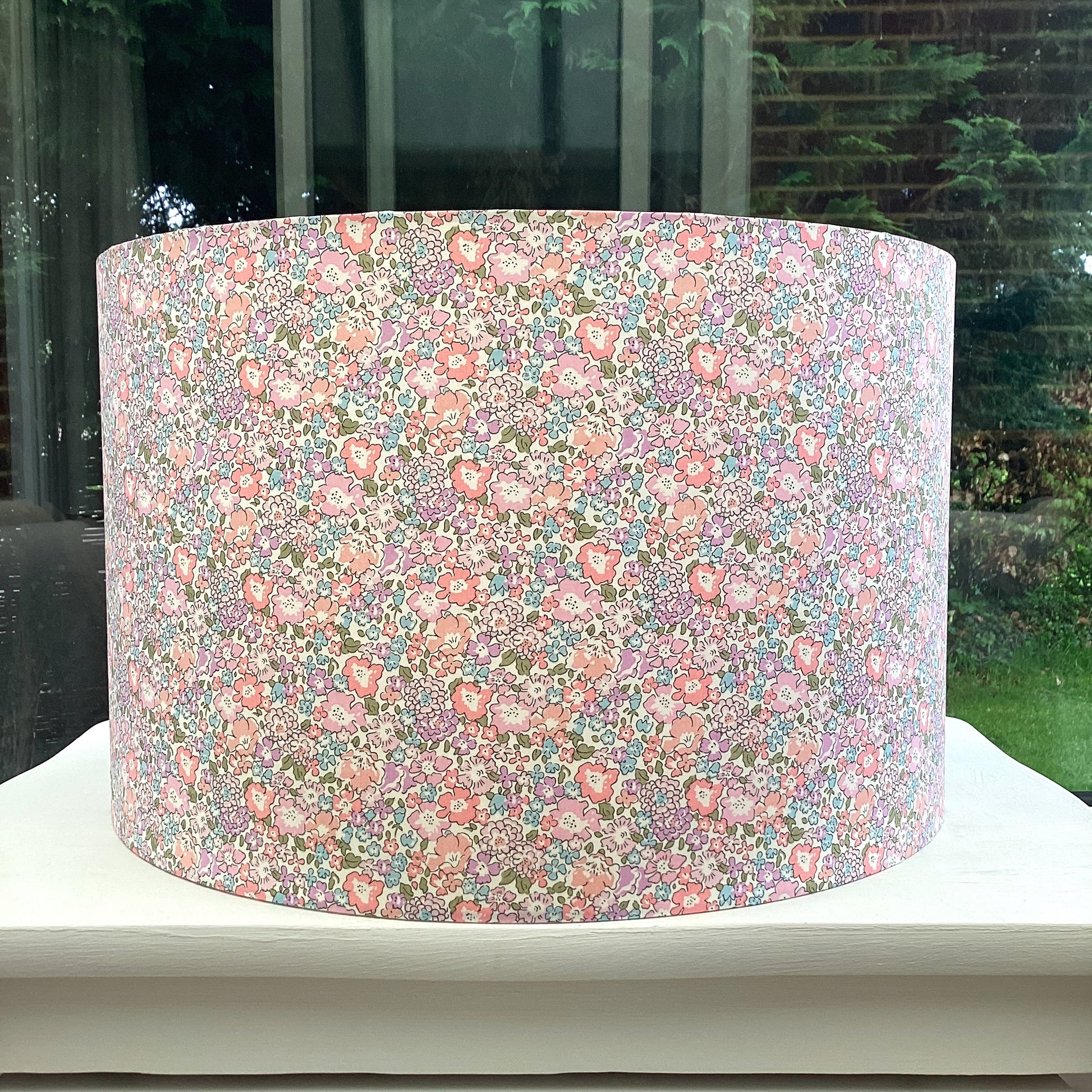 Handcrafted fabric lampshade with a vibrant floral Liberty print in shades of pink, green, and blue, adding a touch of color and elegance to any room decor.