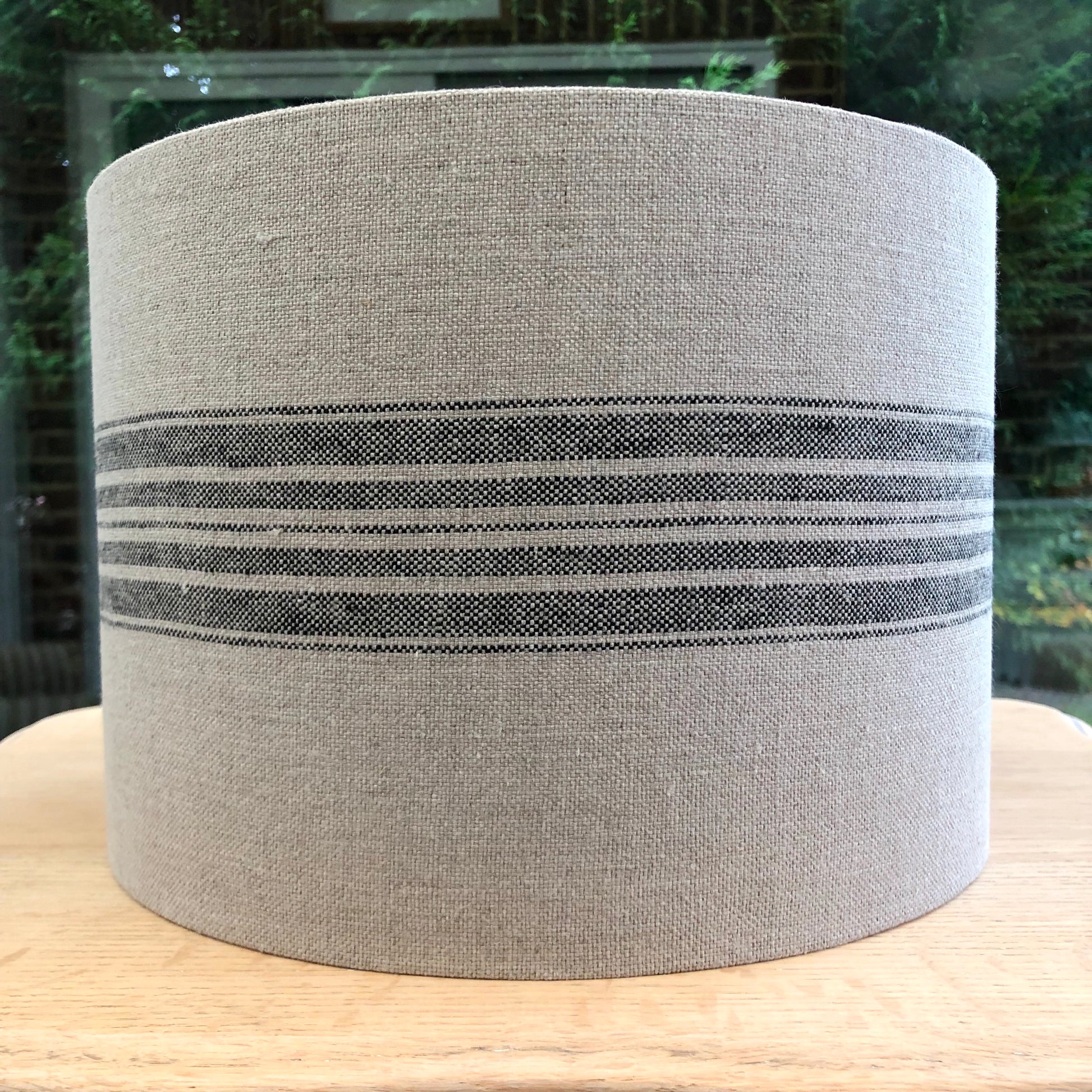 Stylish linen lampshade with black stripes, offering a modern and sophisticated design to complement contemporary home decor.