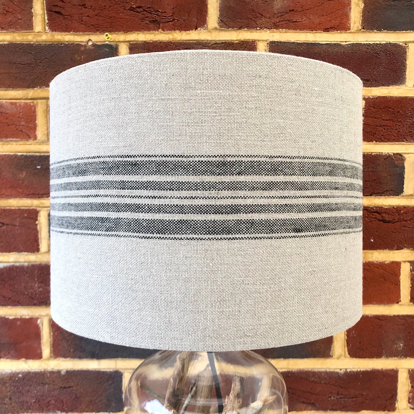 Stylish linen lampshade with black stripes, offering a modern and sophisticated design to complement contemporary home decor.