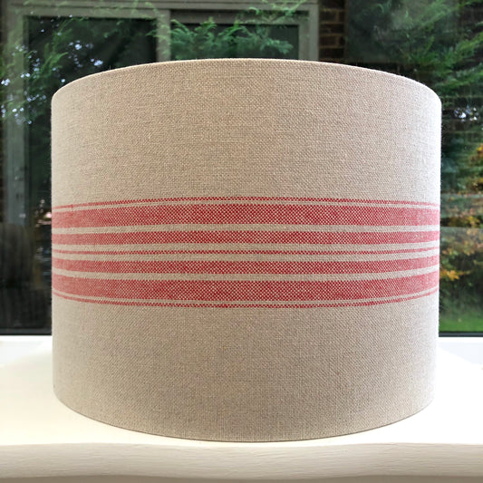 A stylish linen lampshade with bold red stripes, adding a pop of color and texture to any room’s decor.