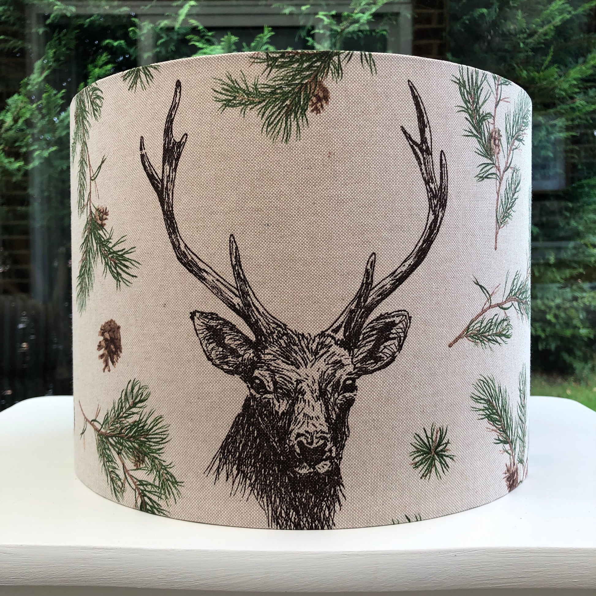 Rustic stag head lampshade with a detailed pine forest design, perfect for woodland-themed decor and cozy interior lighting.