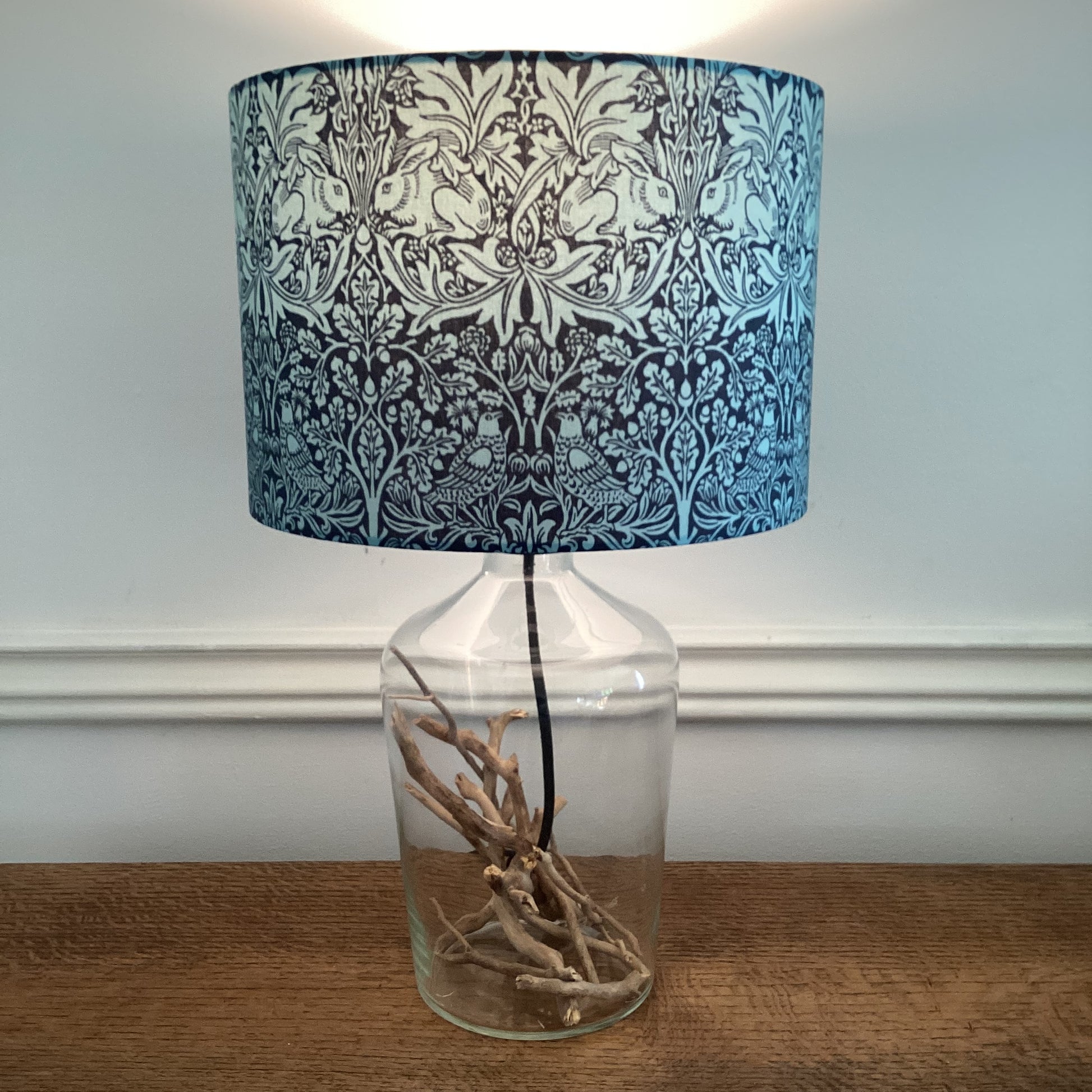 A lampshade featuring a whimsical Brer Rabbit design in navy and teal colors, adding charm to any space.