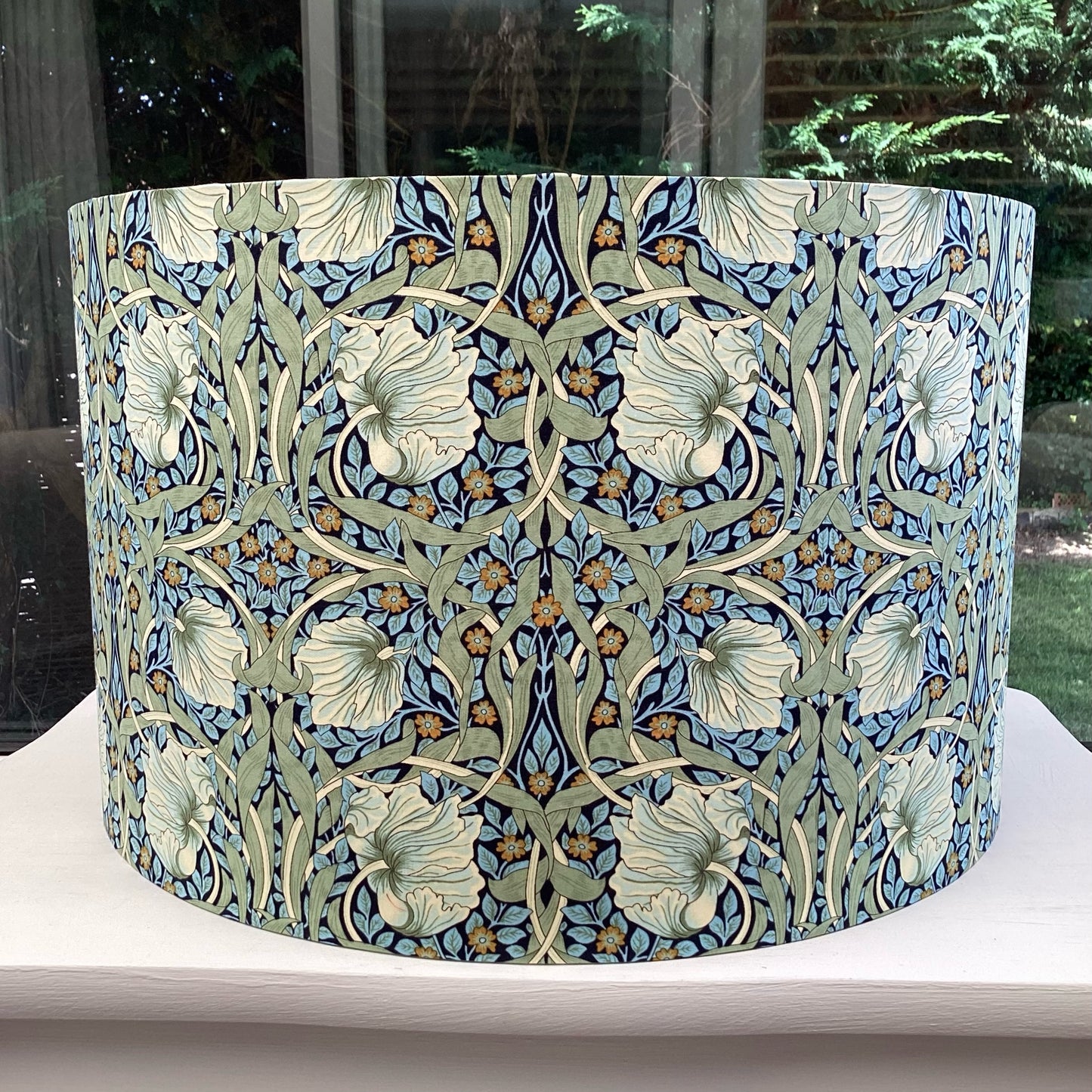 Colorful lampshade featuring a vibrant blue and green floral pattern, adding a lively touch to any space.