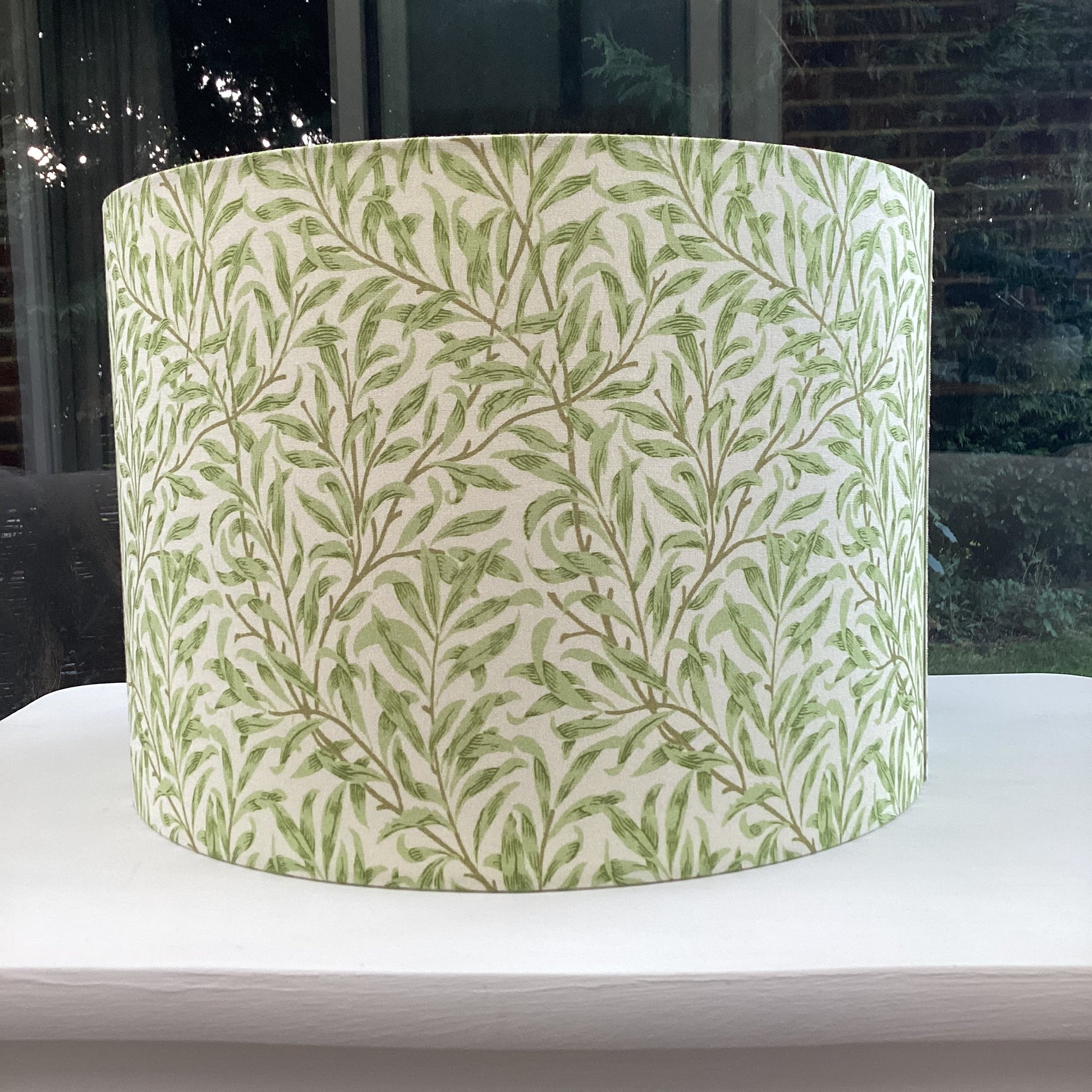 Green coloured lampshade featuring a delicate willow bough pattern, offering a serene and nature-inspired ambiance.