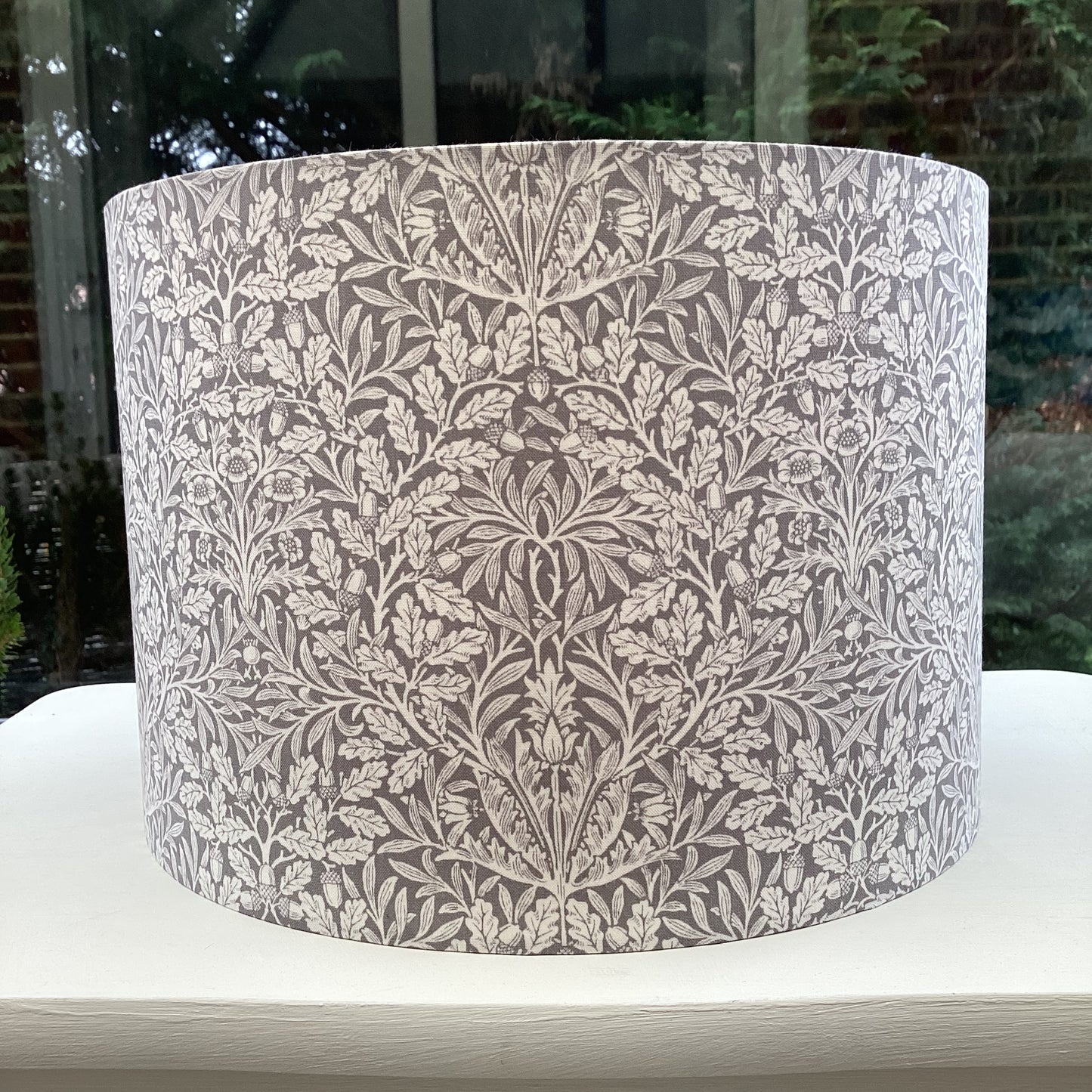 Gray lampshade featuring an artistic acorn pattern, adding a touch of nature-inspired charm to any space.
