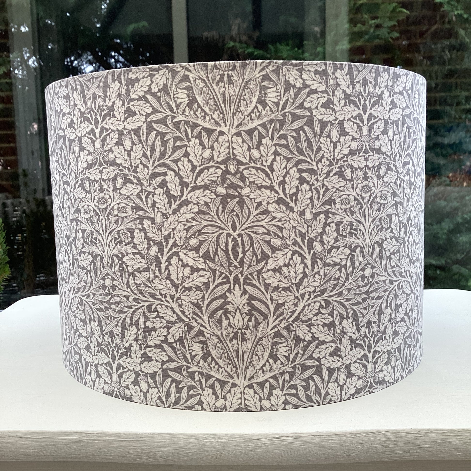 Gray lampshade featuring an artistic acorn pattern, adding a touch of nature-inspired charm to any space.
