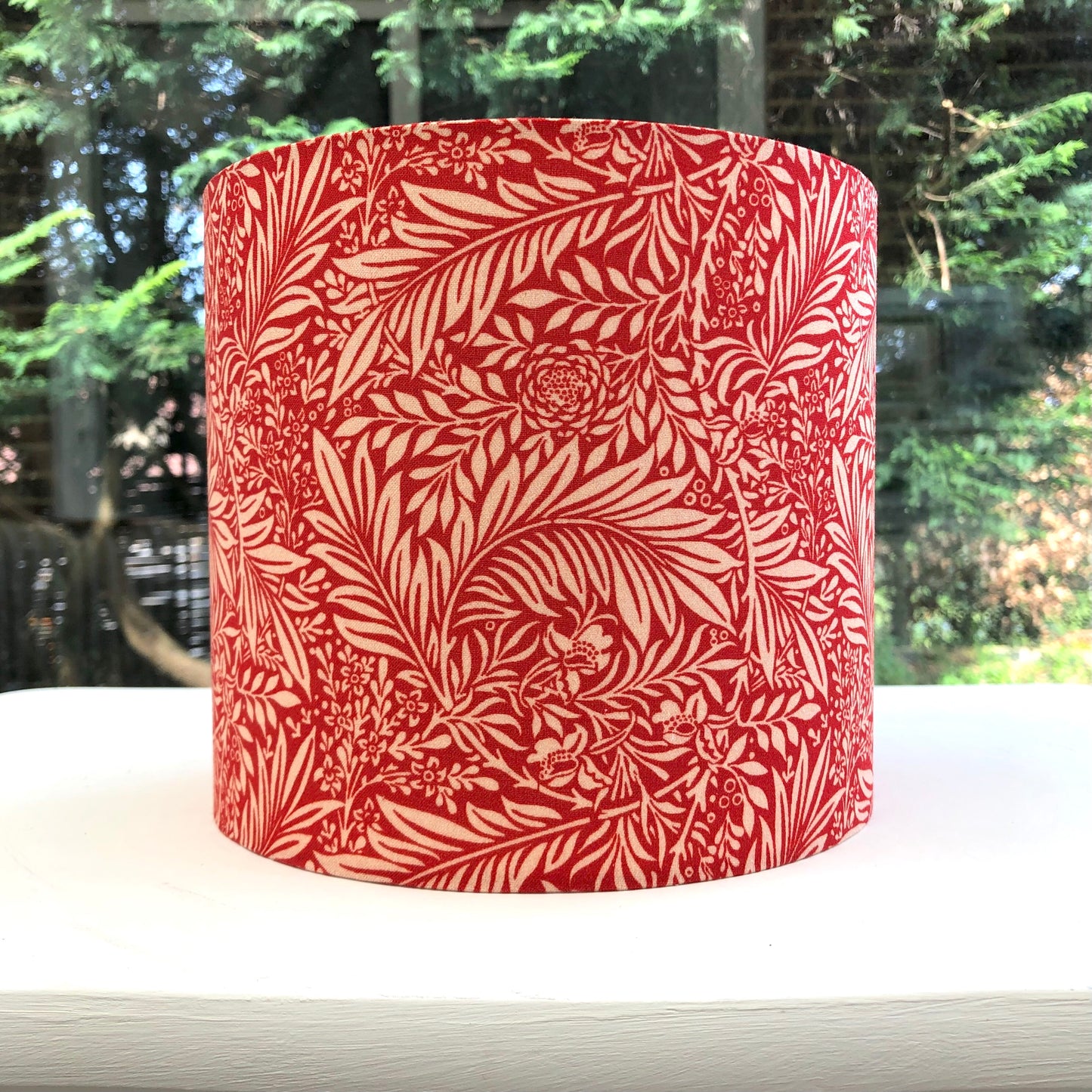 Muted red colored lampshade with larkspur flower design, adding a pop of color and nature-inspired charm to any space.