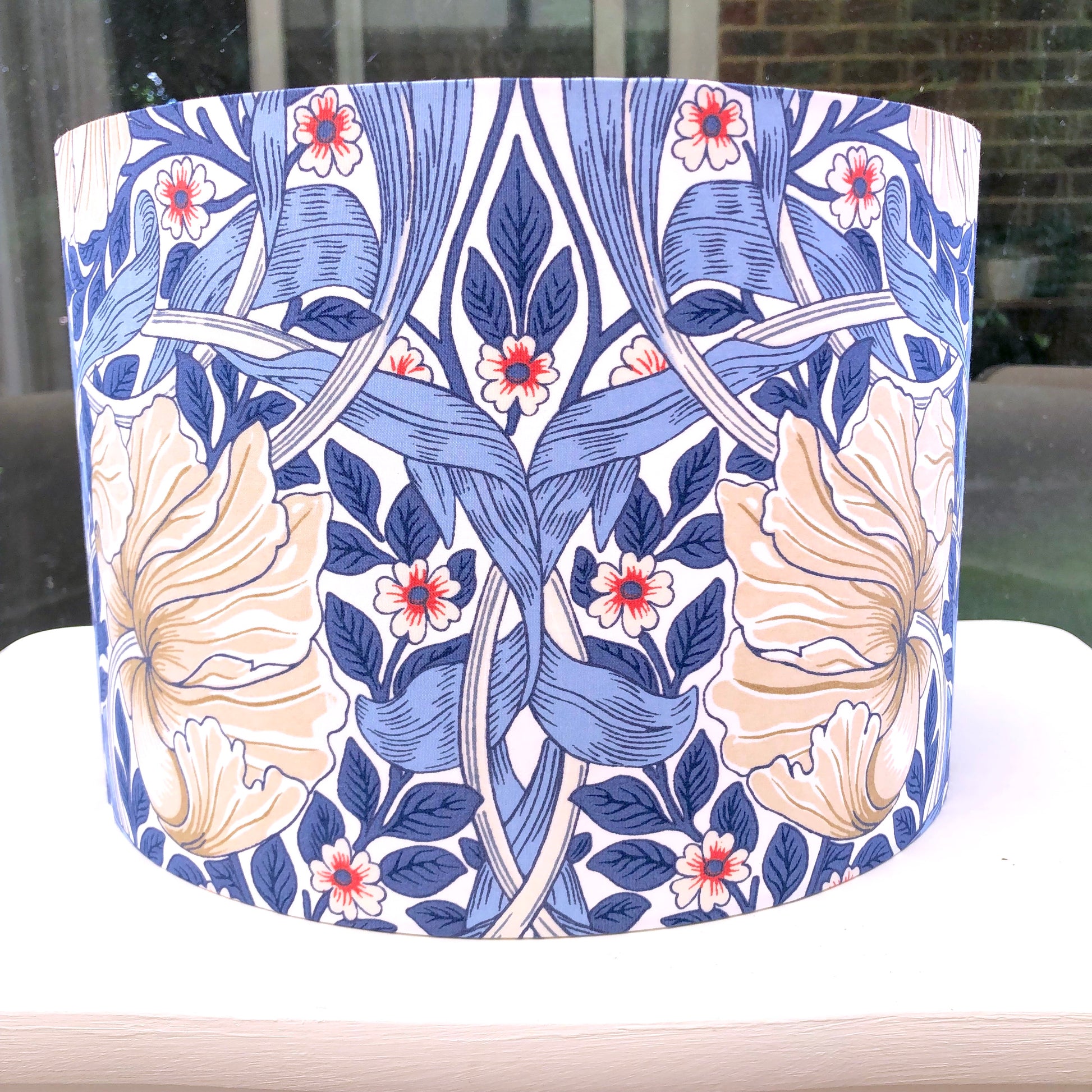 A classic William Morris Pimpernel Blue lampshade, featuring intricate floral and foliage patterns, handcrafted for timeless elegance and style.