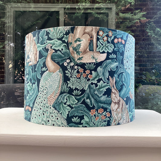 Handcrafted William Morris lampshade in the Standen Forest design, showcasing intricate green and cream botanical patterns, perfect for adding timeless elegance to home lighting decor.