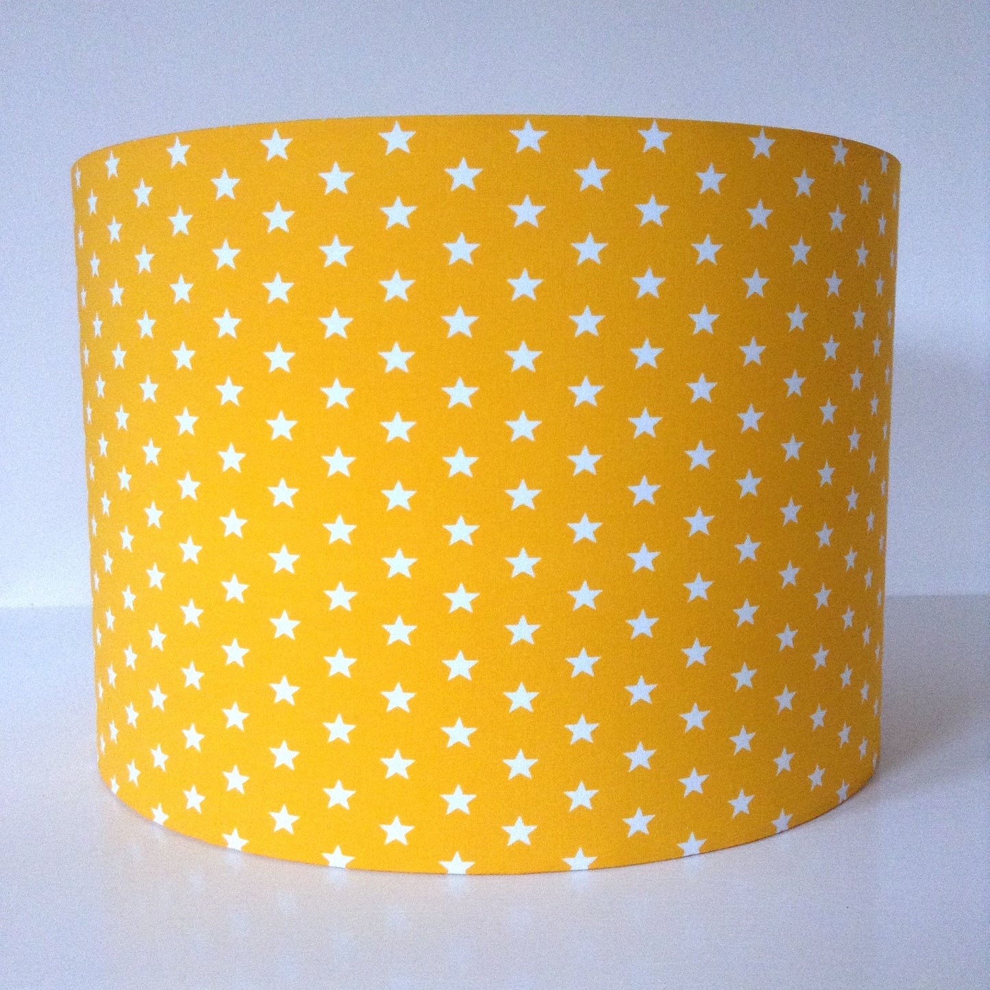 Yellow lampshade adorned with scattered star patterns, emitting a cozy and celestial glow.